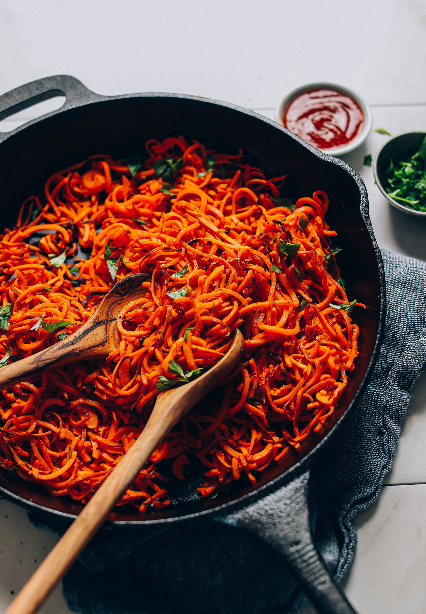 Using wooden spoons to grab a serving of Sweet Potato Hashbrowns for a delicious vegan side