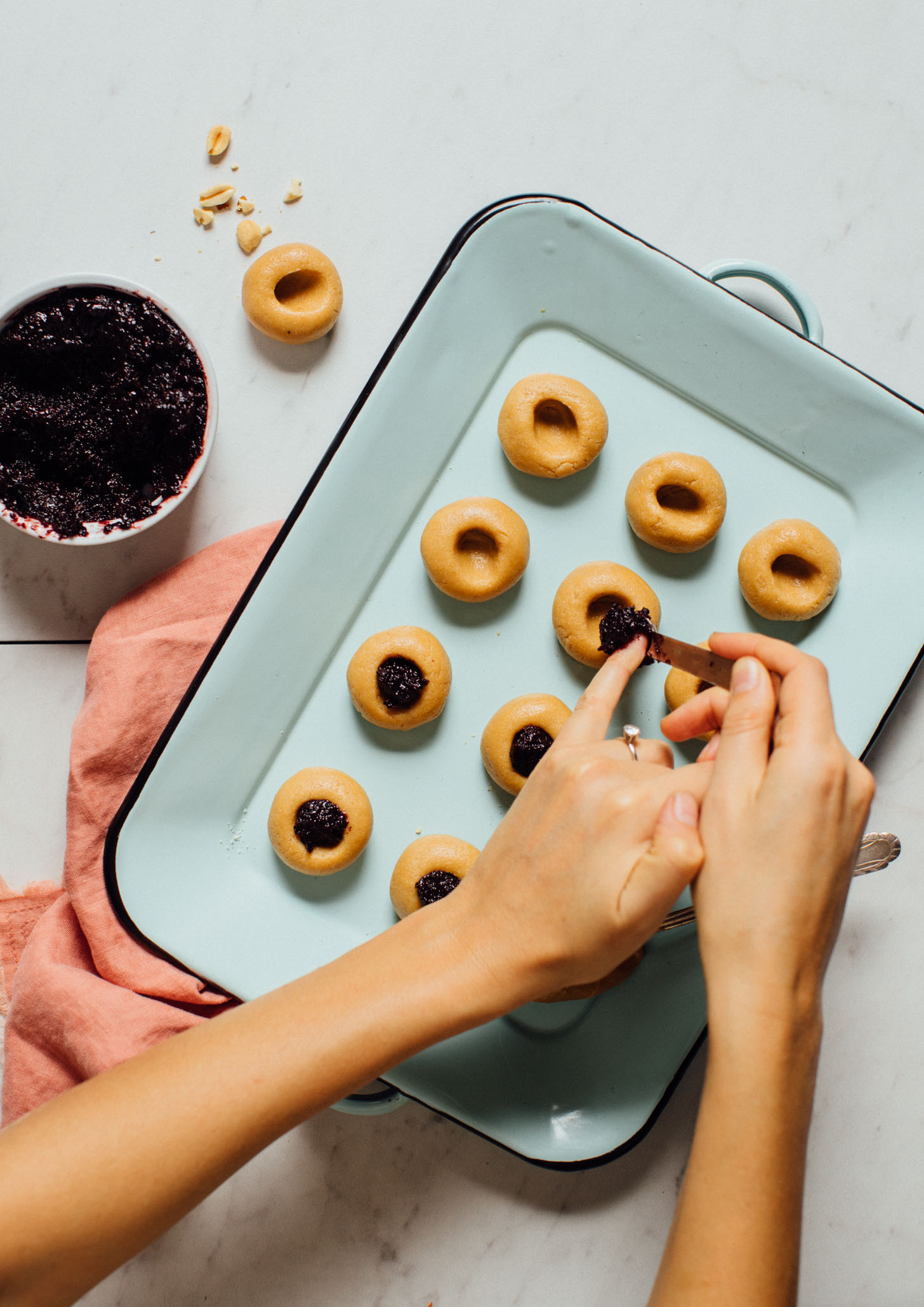 Adding jam to the center of a Peanut Butter Thumbprint Cookie