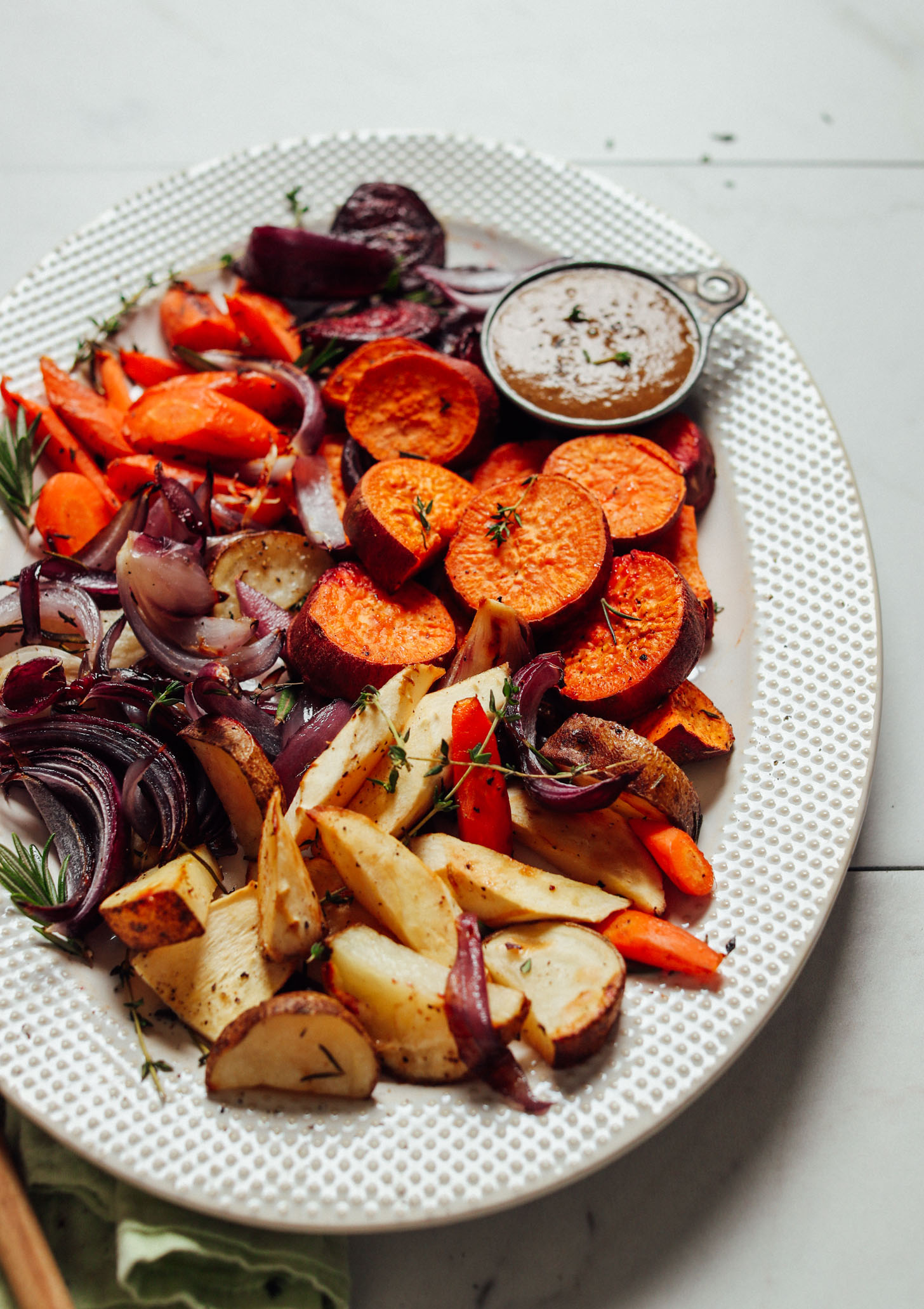 A backlit view of a platter of pan roasted vegetables with vegan gravy