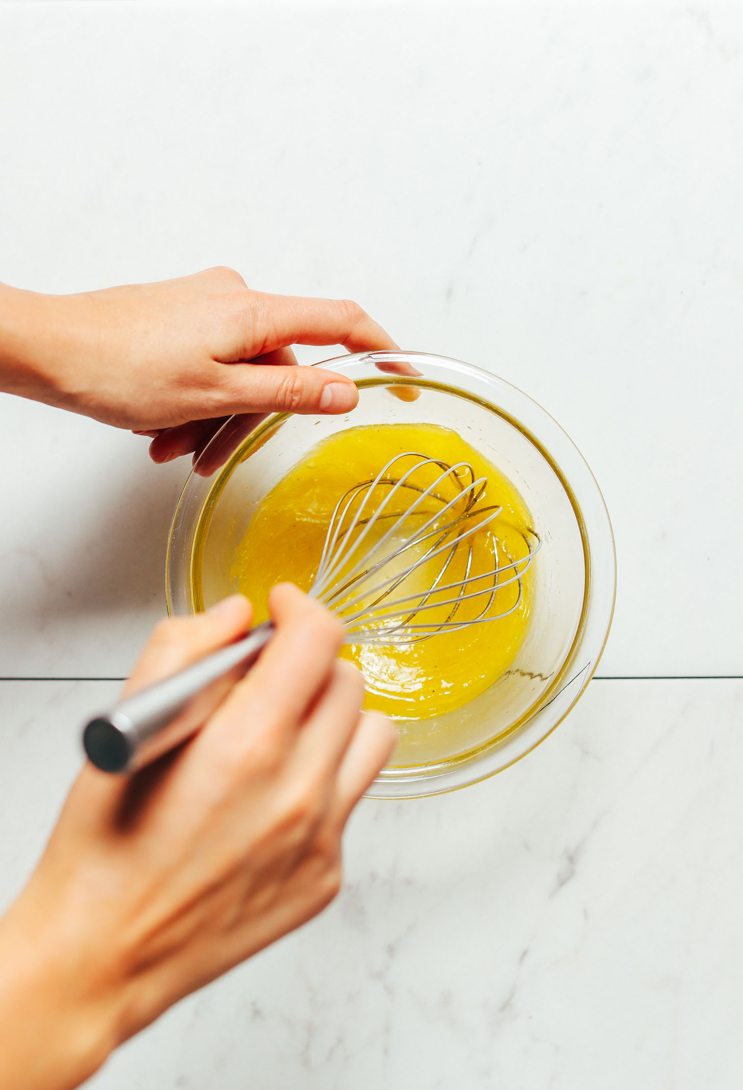 Using a whisk to stir together ingredients for homemade Lemon Vinaigrette