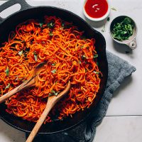 Skillet of Sweet Potato Hashbrowns alongside fresh parsley and ketchup