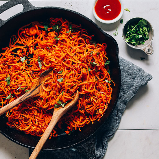 Skillet of Sweet Potato Hashbrowns alongside fresh parsley and ketchup