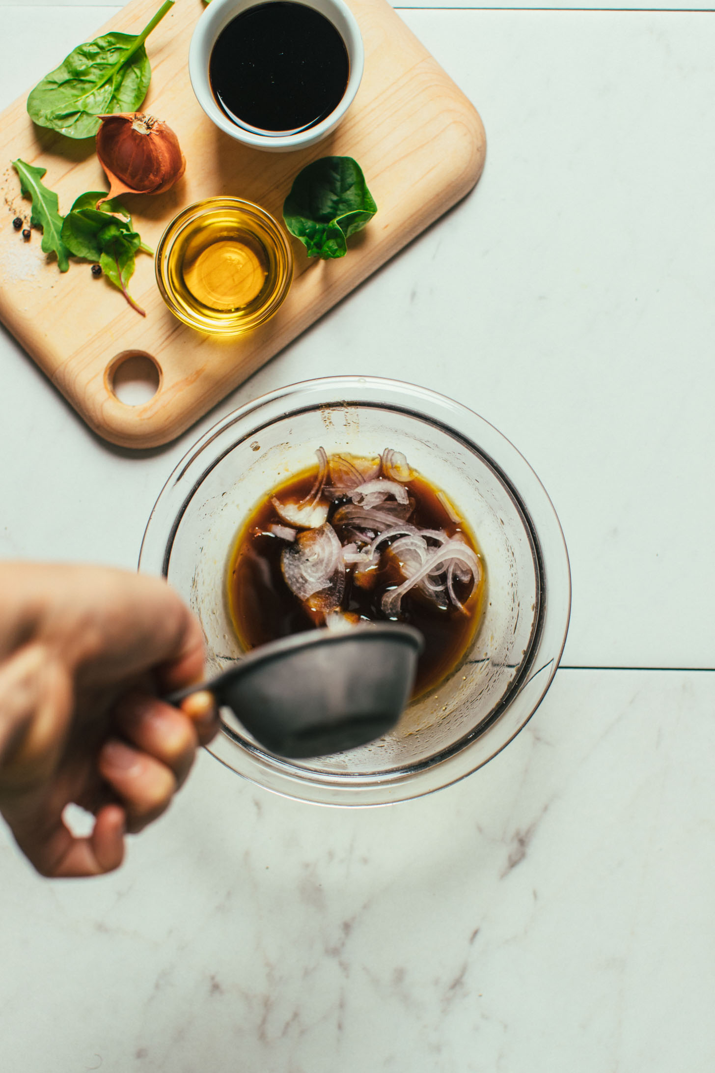 Pouring shallot into a bowl for our Balsamic Vinaigrette Dressing