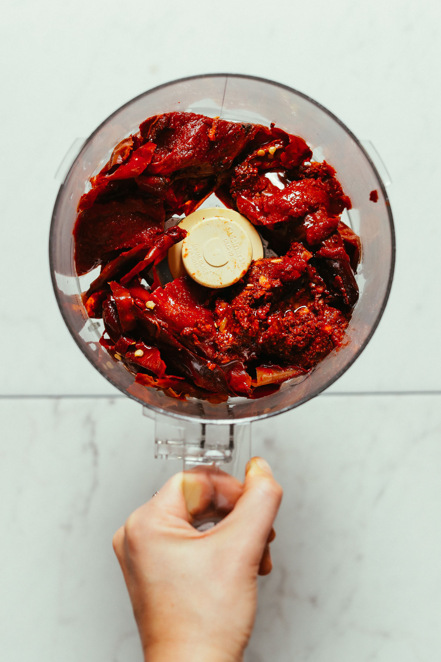 Overhead image of soaked deseeded peppers in a food processor