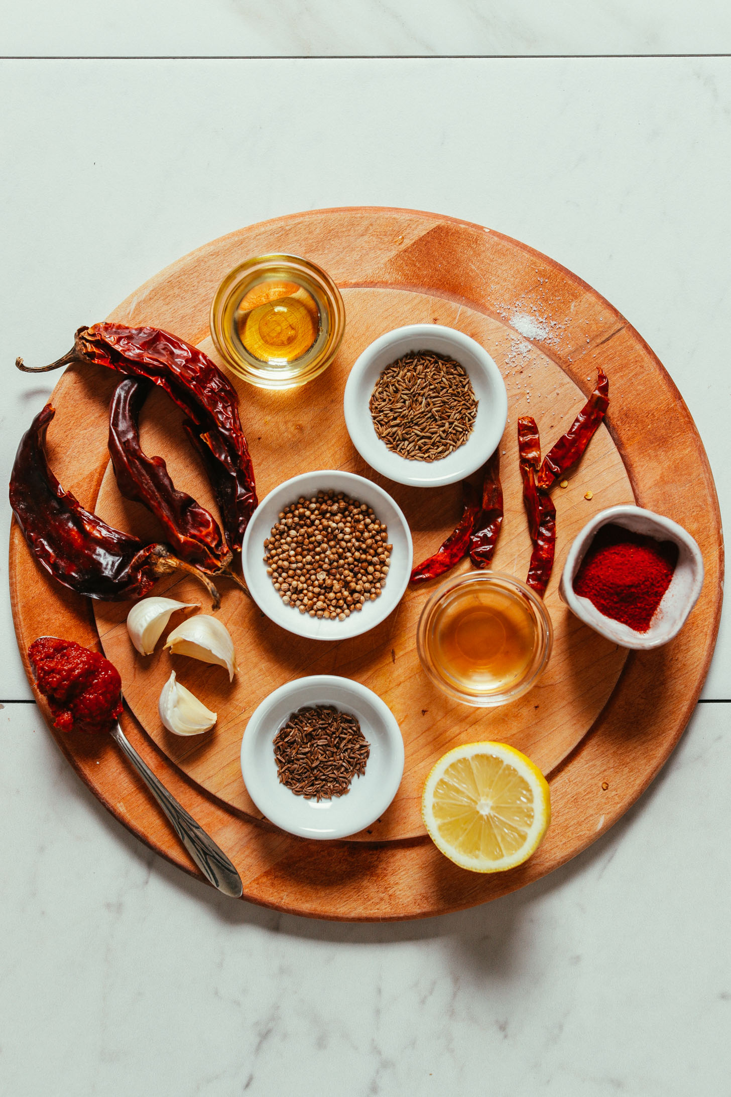 Cutting board with dried chiles, spices, garlic, oil, and lemon