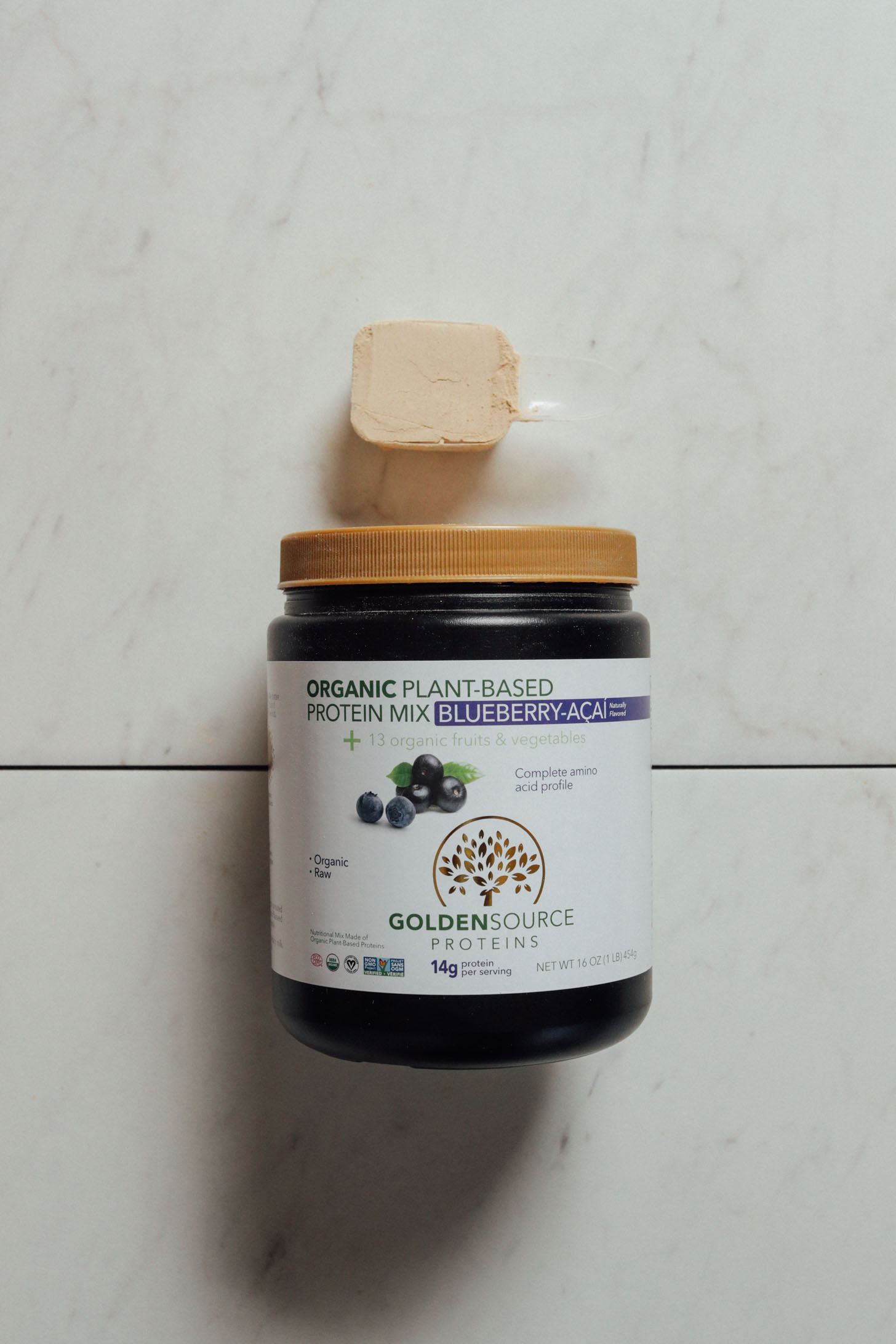 Tub and scoop of Goldensource Blueberry Acai Protein Powder for our review