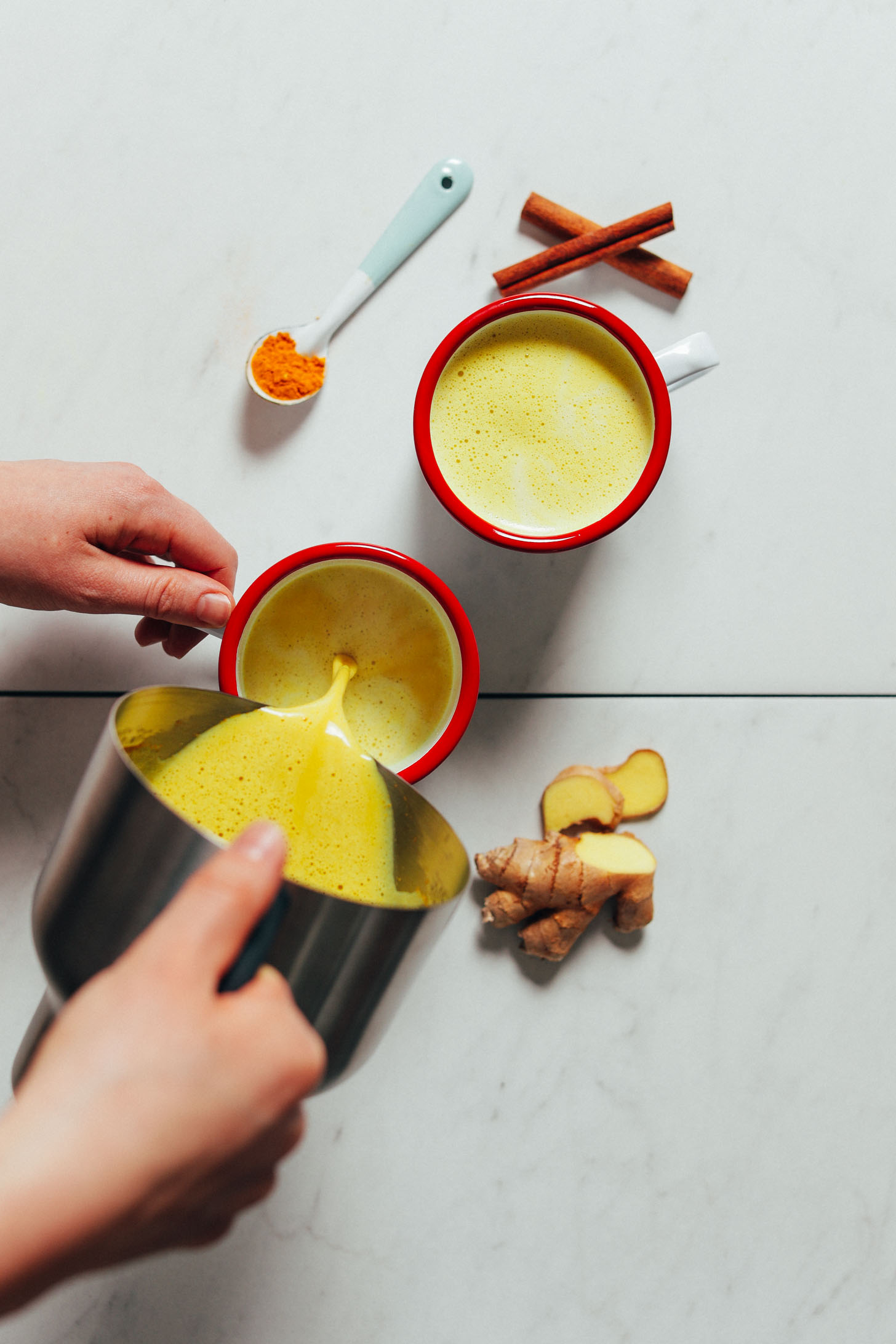 Pouring vegan golden milk from our milk frother into mugs