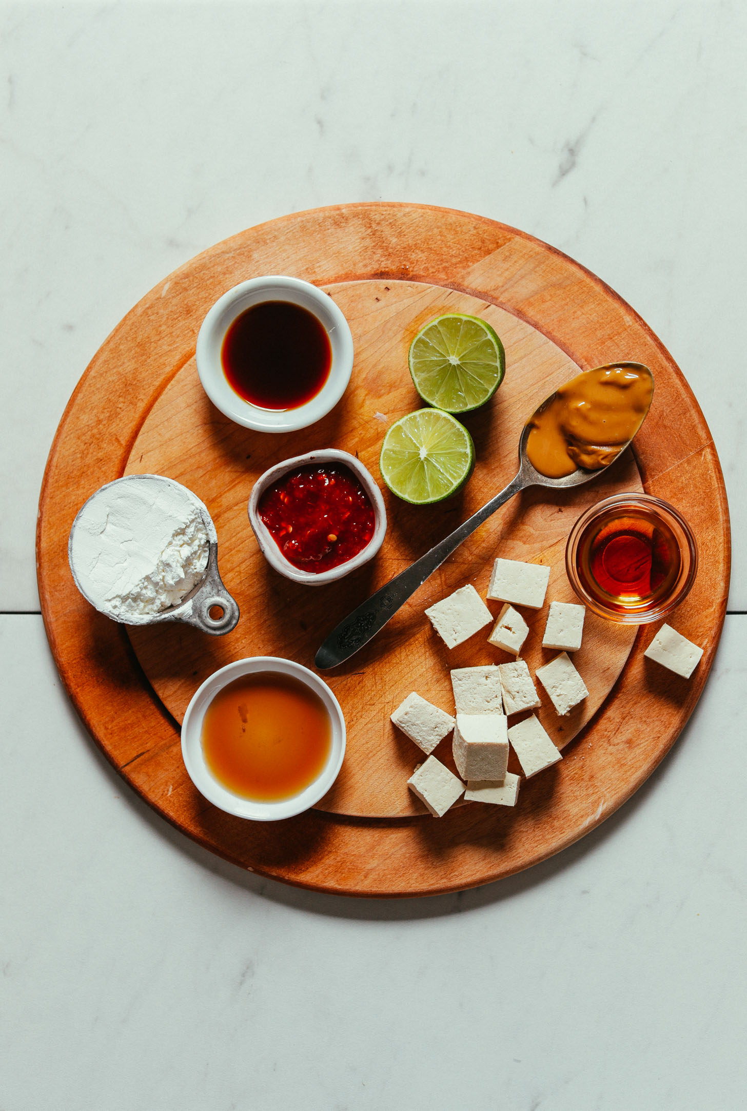 Wood cutting board with ingredients for making our Quick & Easy Peanut Tofu recipe