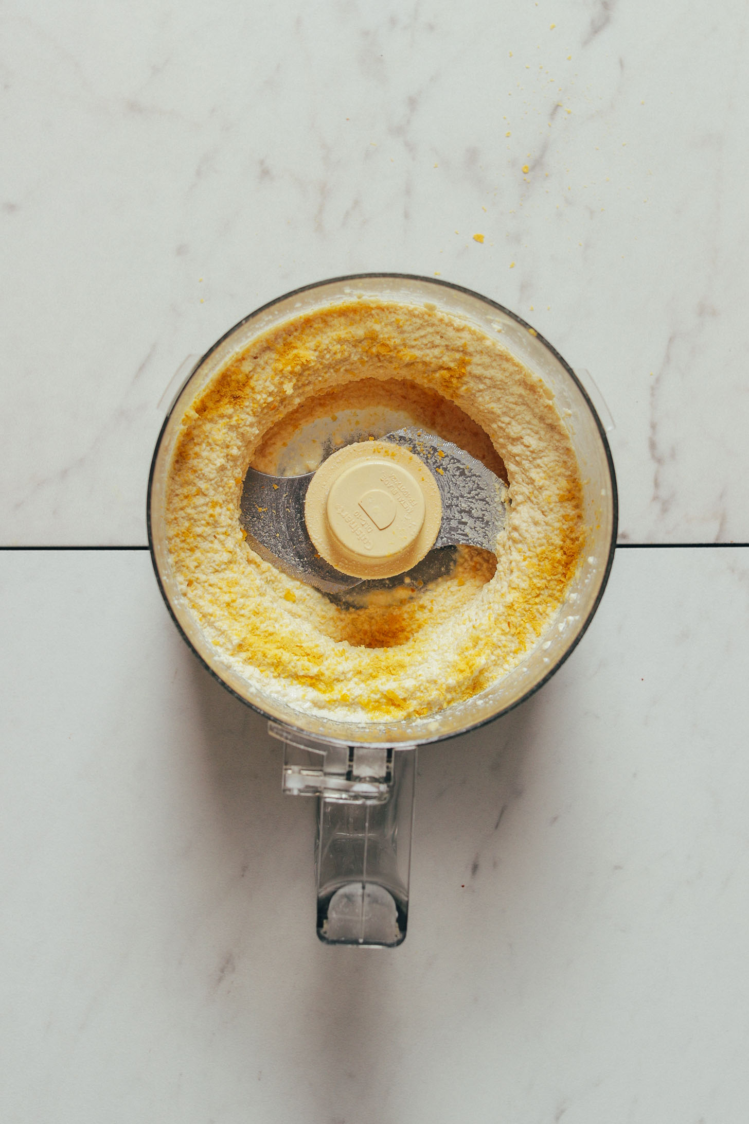Food processor filled with a batch of freshly made Macadamia Ricotta for Vegan Lasagna