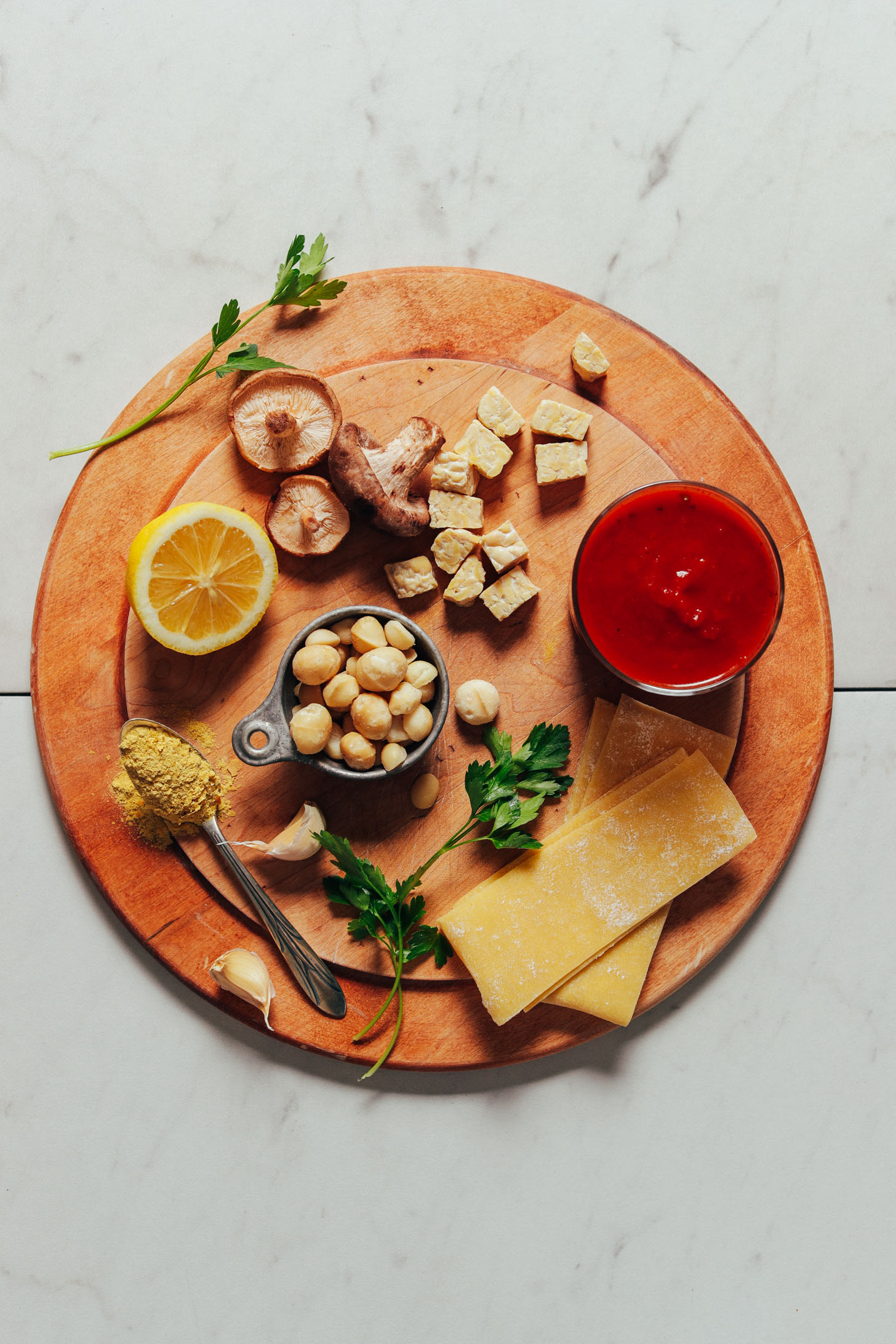 Wood cutting board with ingredients for making our AMAZING Vegan Lasagna recipe