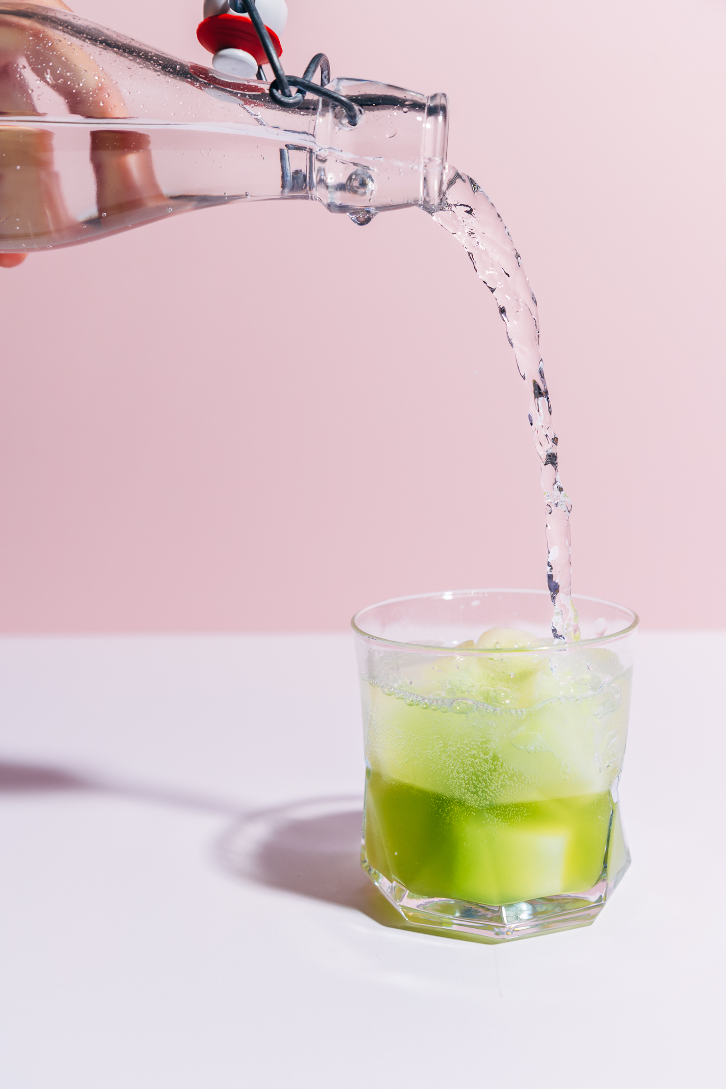 Pouring sparkling water into a glass to make a Citrus and Melon Spritzer for a summertime drink