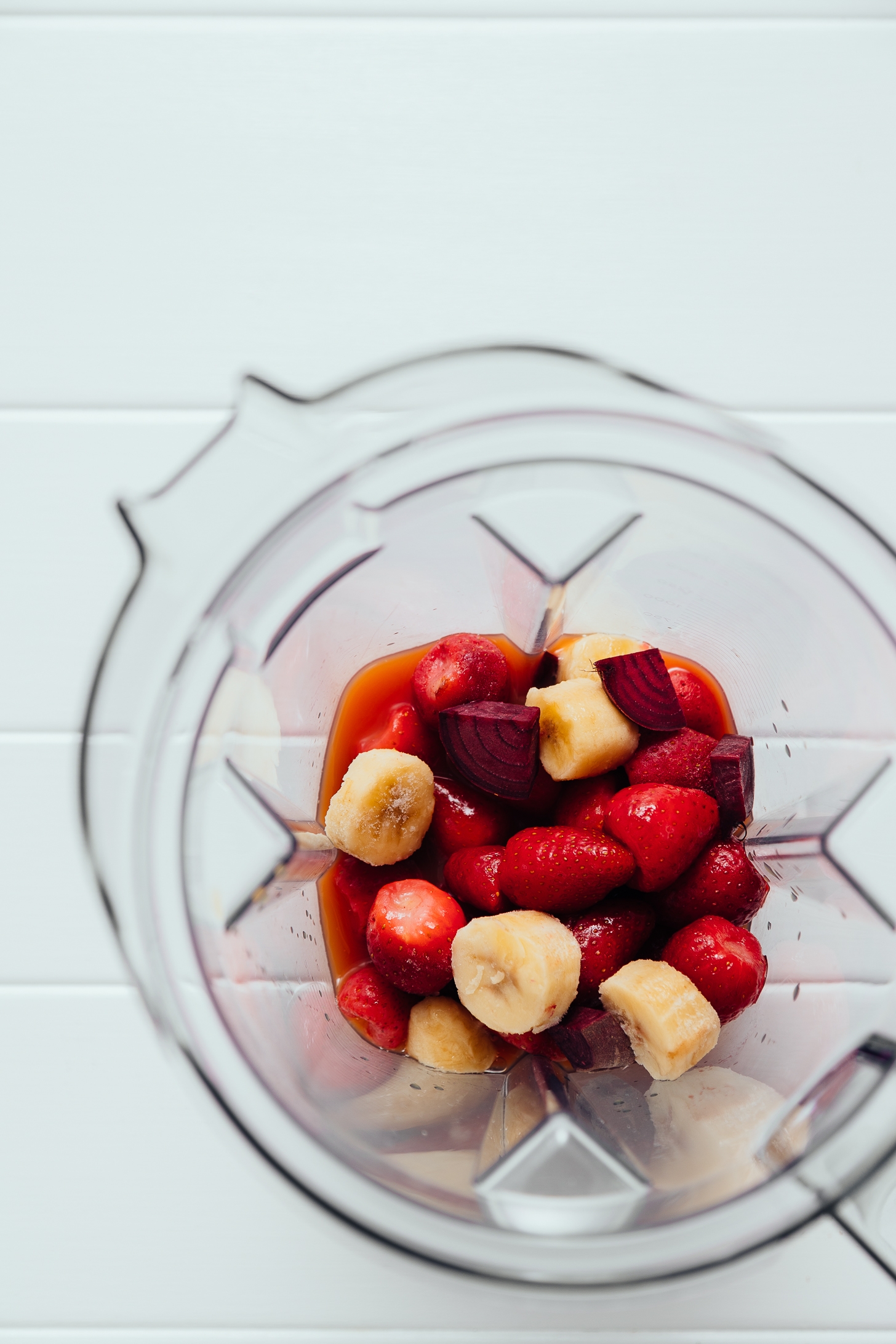 Blender filled with fresh fruit and juice for making a Detoxifying Beet and Berry Smoothie