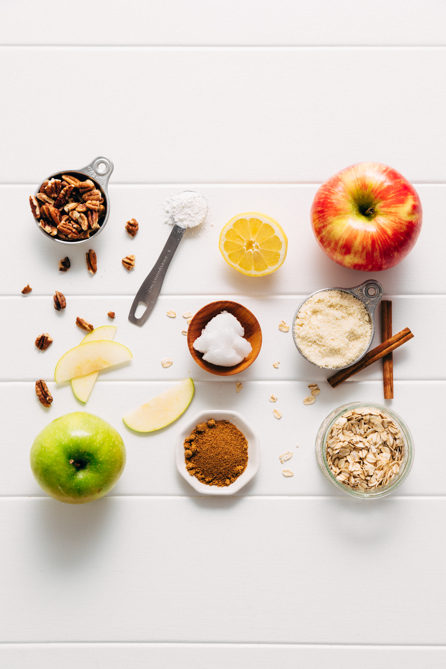 Assortment of ingredients for making our Healthified Apple Crisp recipe with almond meal, oats, and pecans