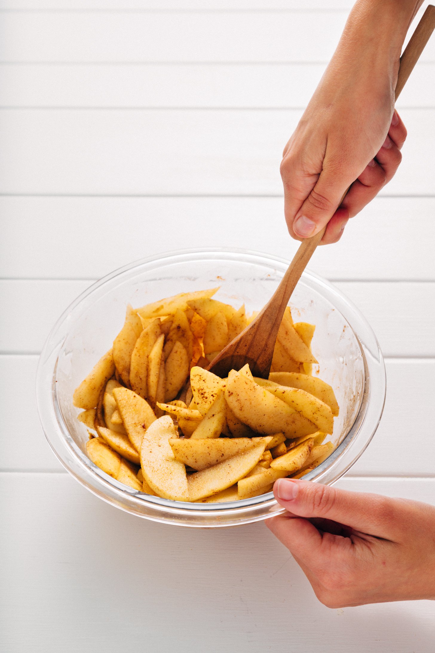 Stirring sliced apples and spices for our Healthified Apple Crisp recipe