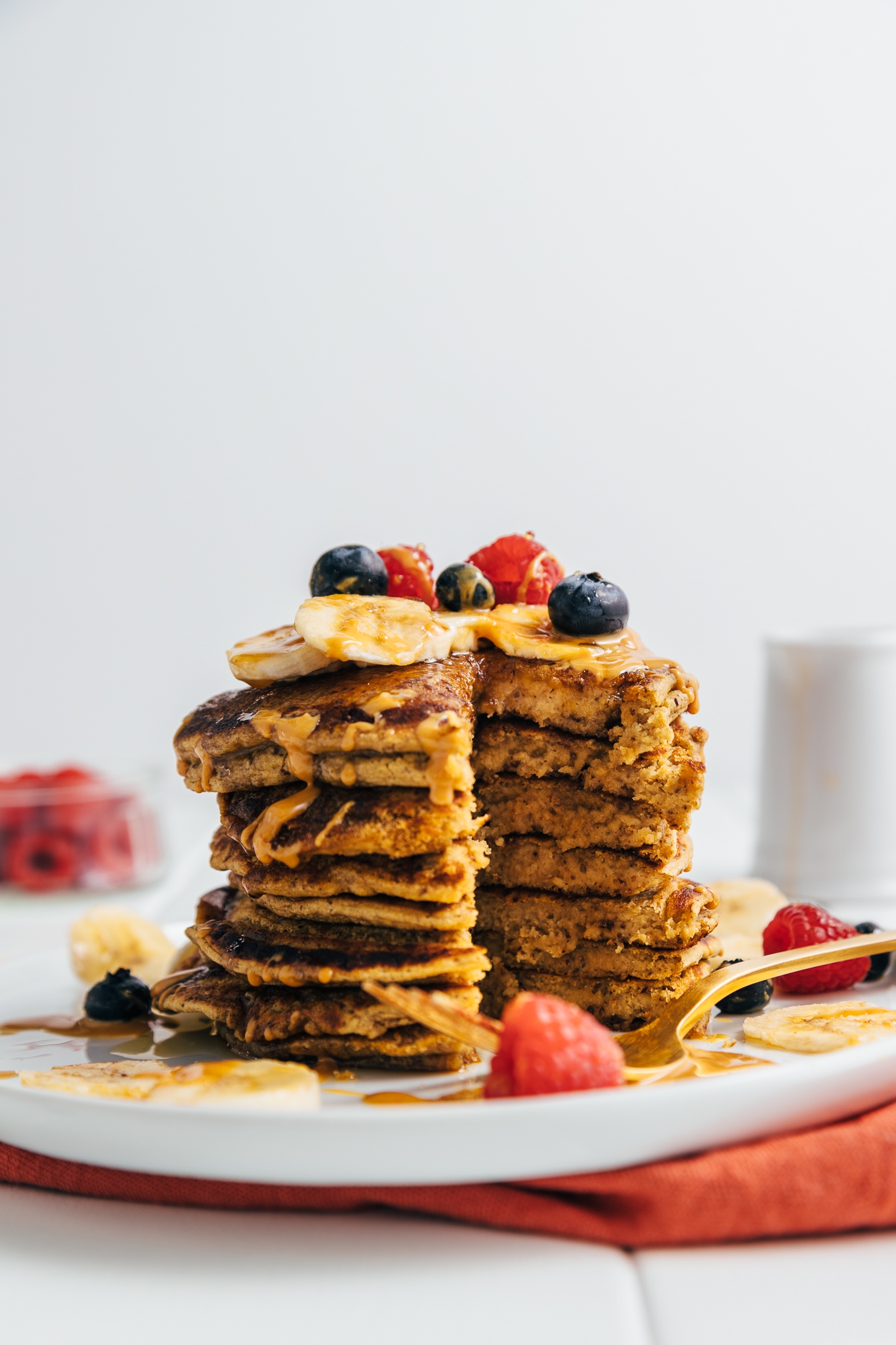 Partially eaten stack of Peanut Butter Protein pancakes topped with fresh fruit
