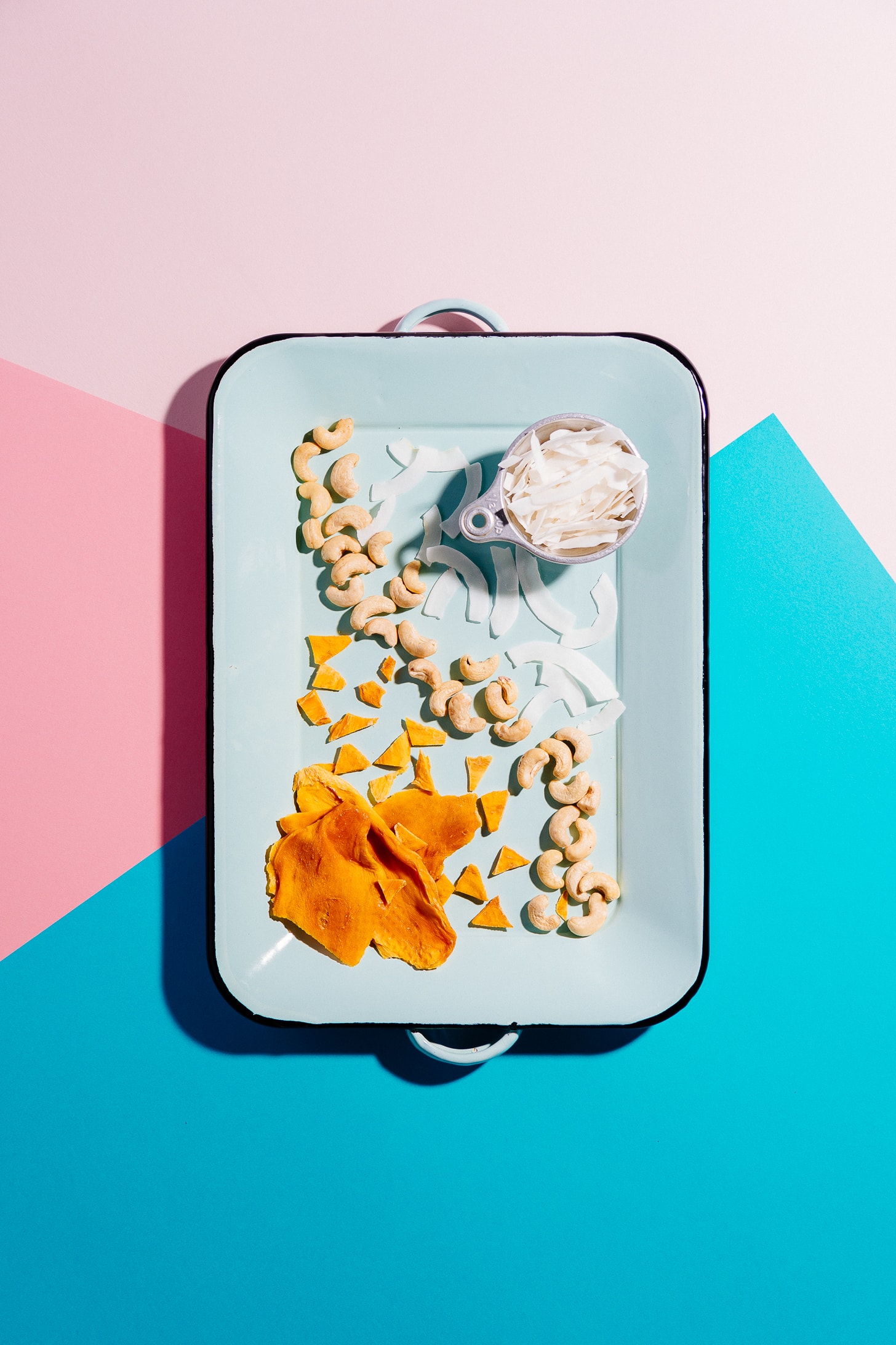 Tray of ingredients for making our Tropical Trail Mix made with dried mango, coconut, and cashews