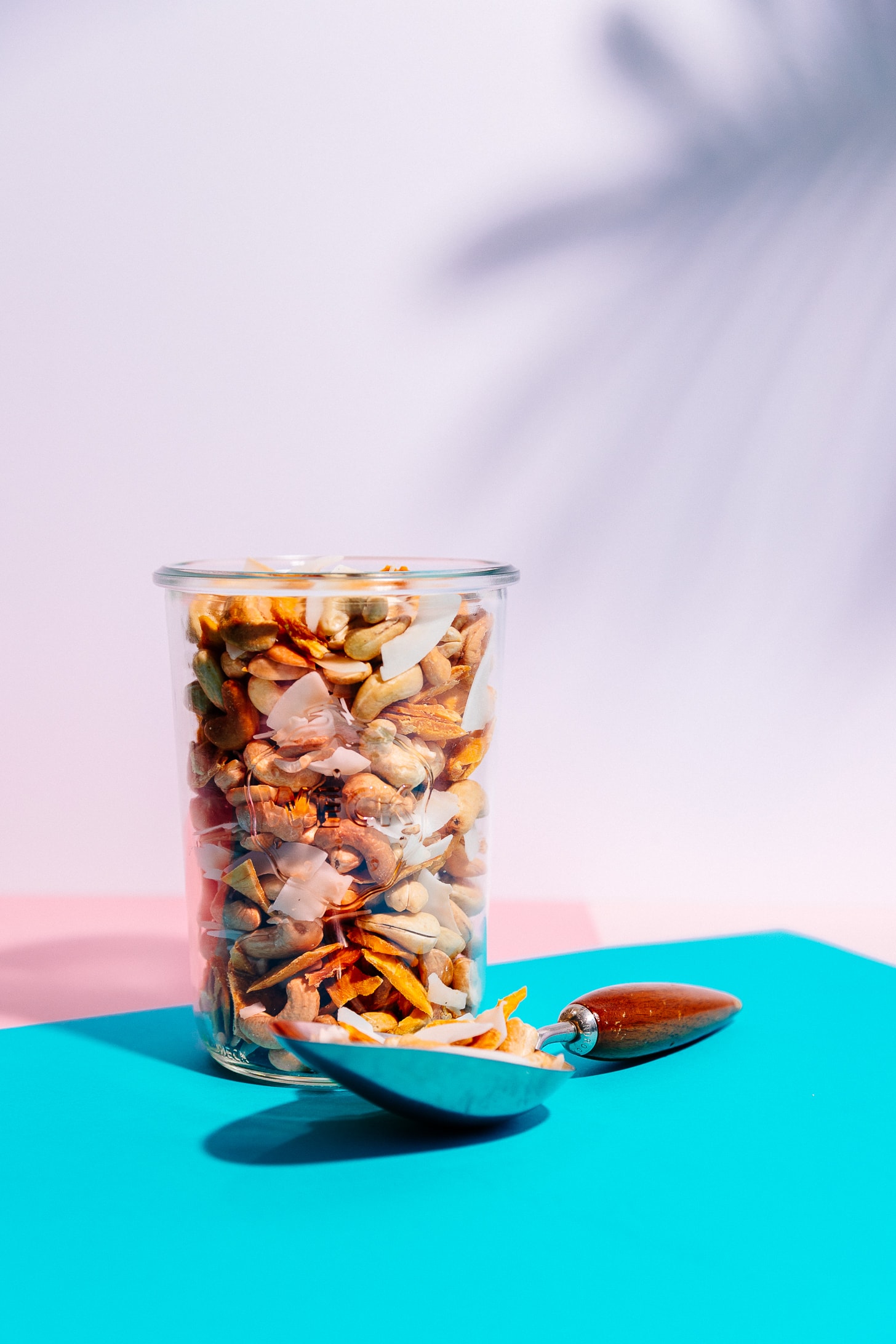 Jar and large spoon filled with simple homemade Tropical Trail Mix