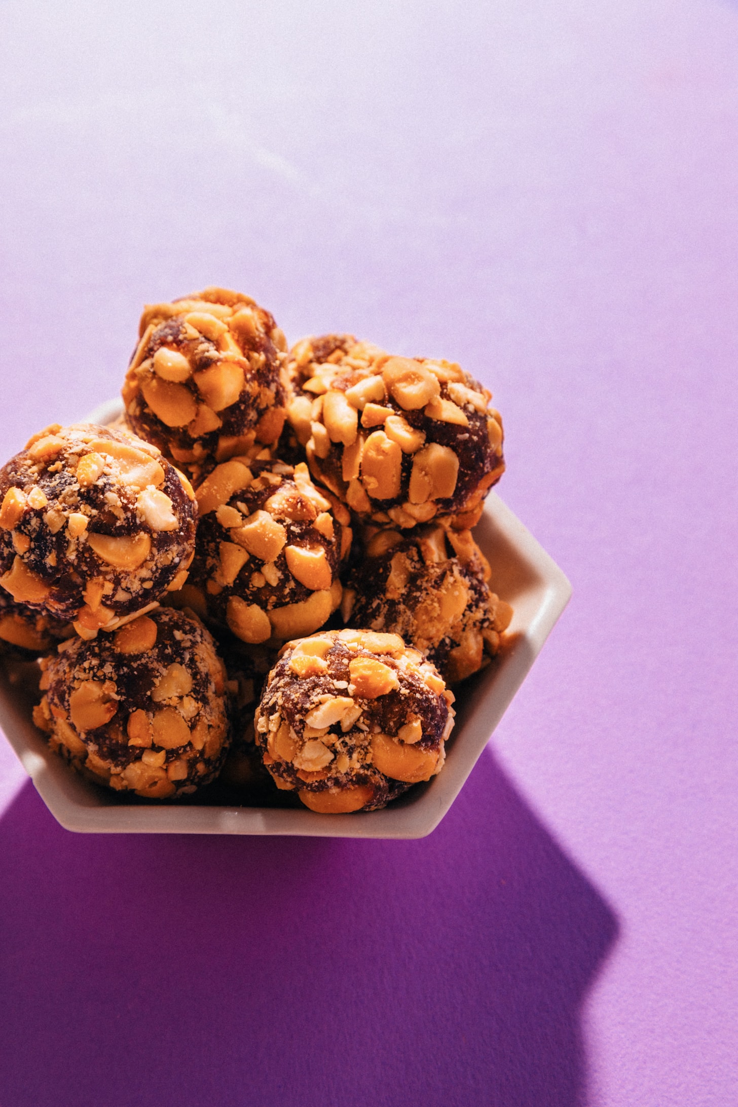 Bowl of our homemade Vegan PayDay Bites candy made with dates and nuts