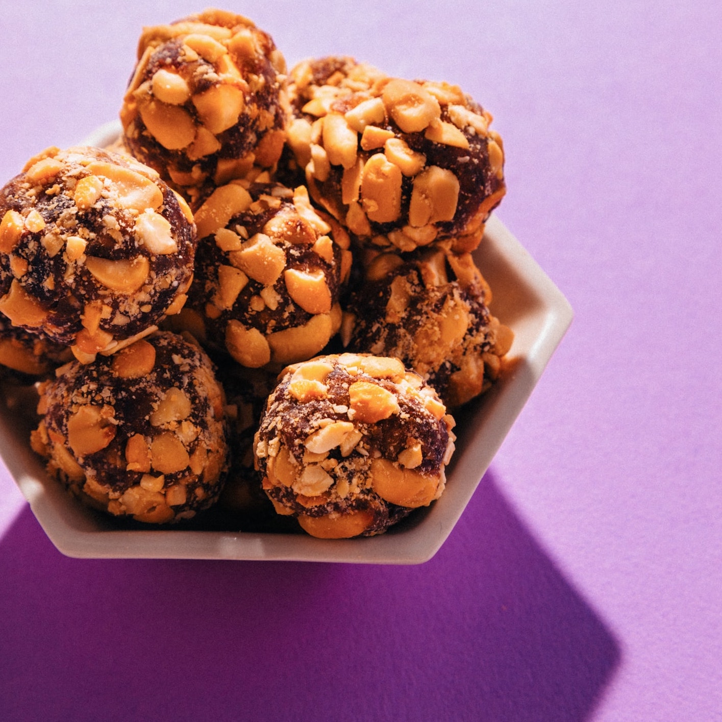 Bowl of Vegan PayDay Bites on a purple background