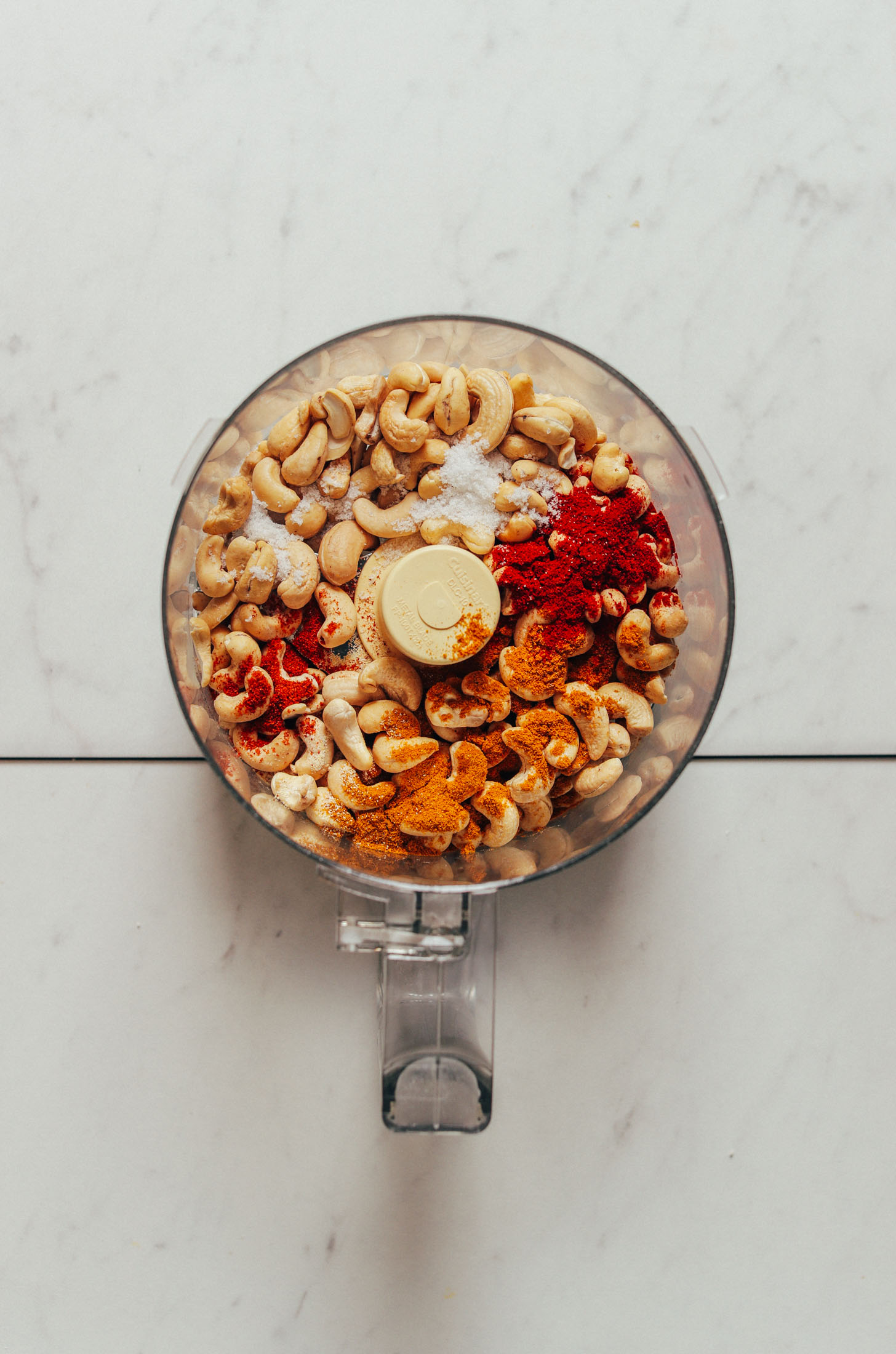 Food processor with cashews and spices for making the coating for our Crusted Cauliflower Steaks recipe
