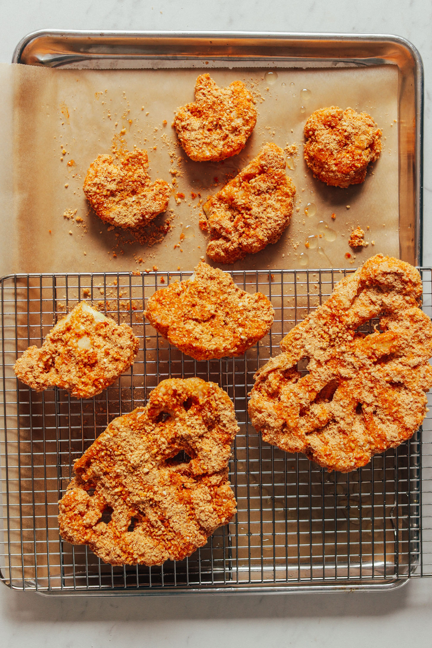 Baking sheet and cooling rack filled with Cashew Crusted Cauliflower Steaks