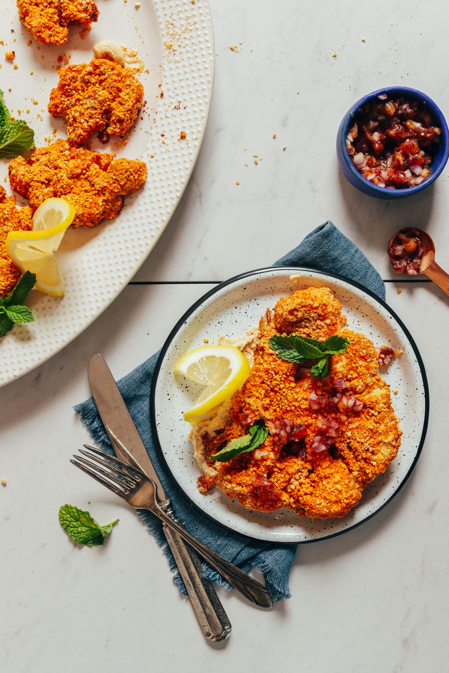 Platter and plate of gluten-free vegan Cauliflower Steaks made with a cashew-based breading