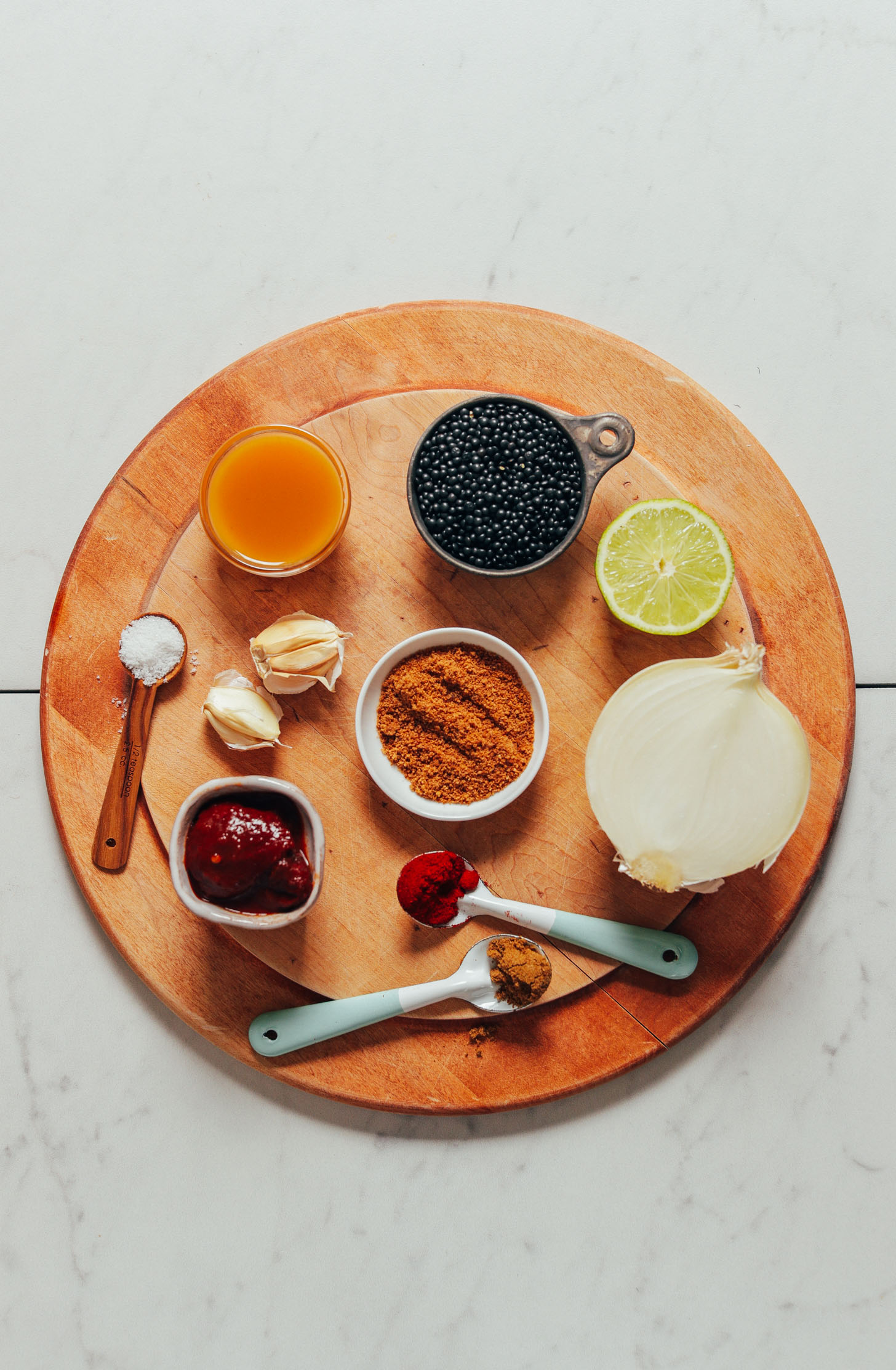 Wood cutting board with ingredients for making Smoky Refried Lentils