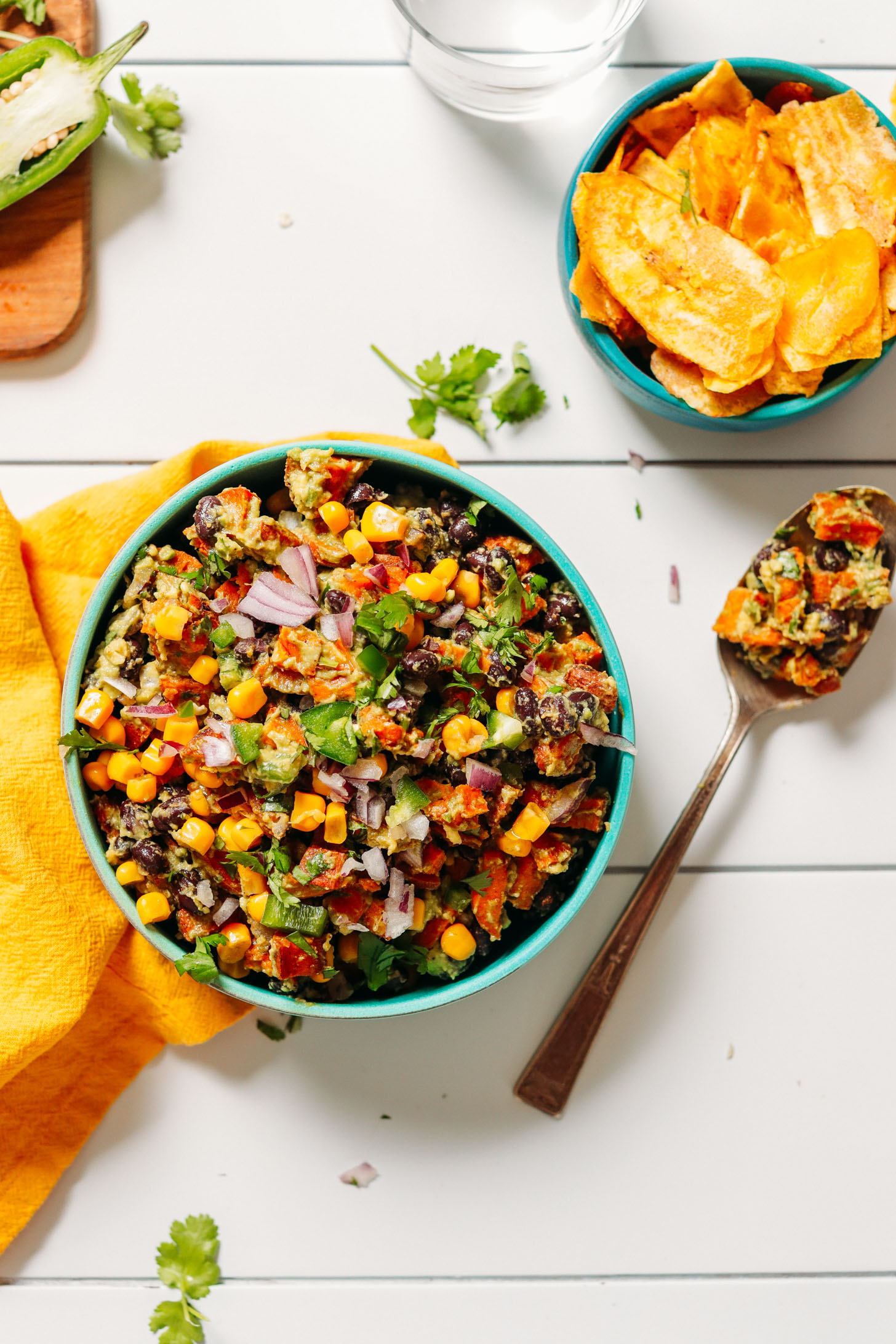 Spoon and bowl of Southwest Sweet Potato Black Bean Dip and a bowl filled with plantain chips