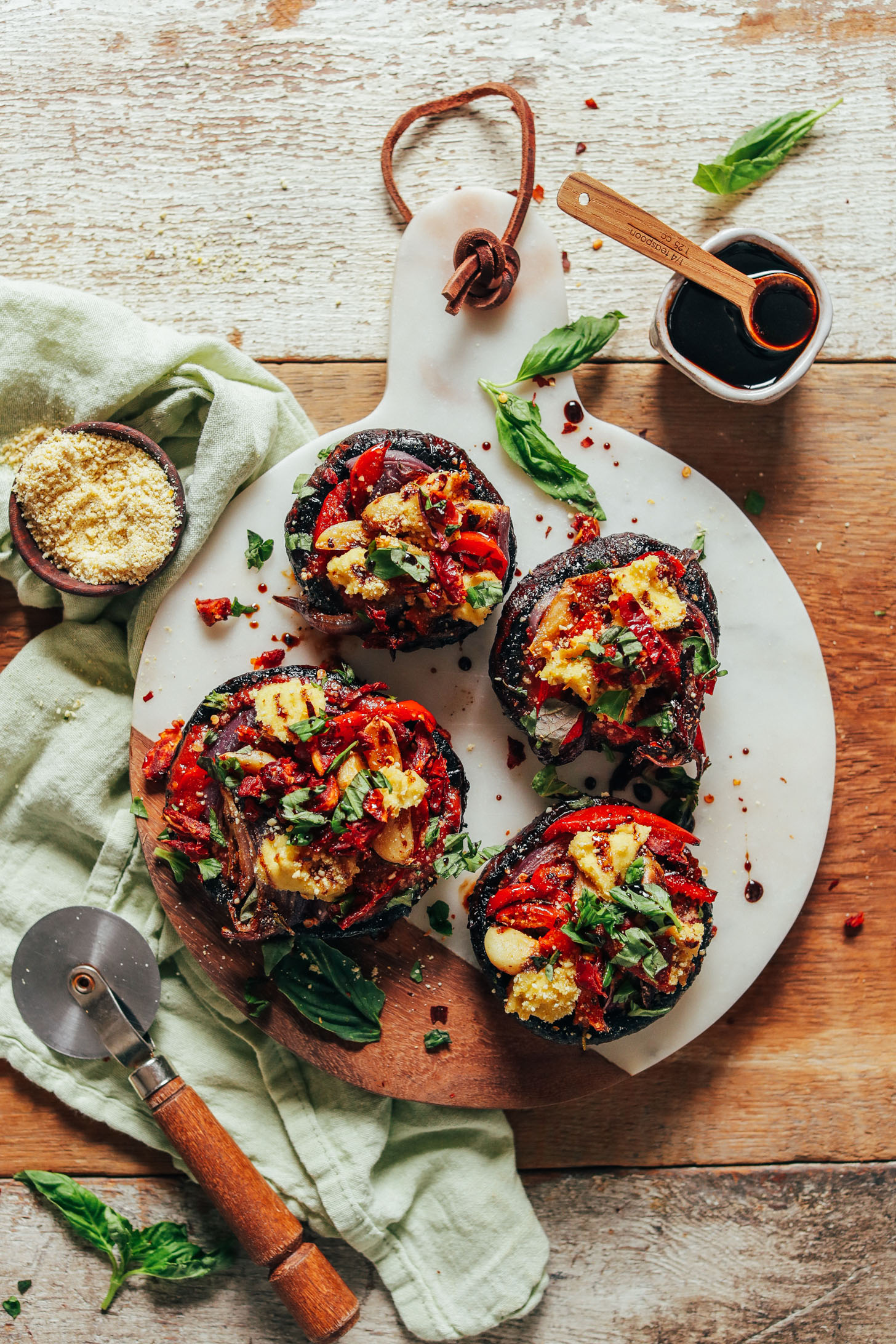 Vegan Portobello Pizzas on a marble and wood cutting board