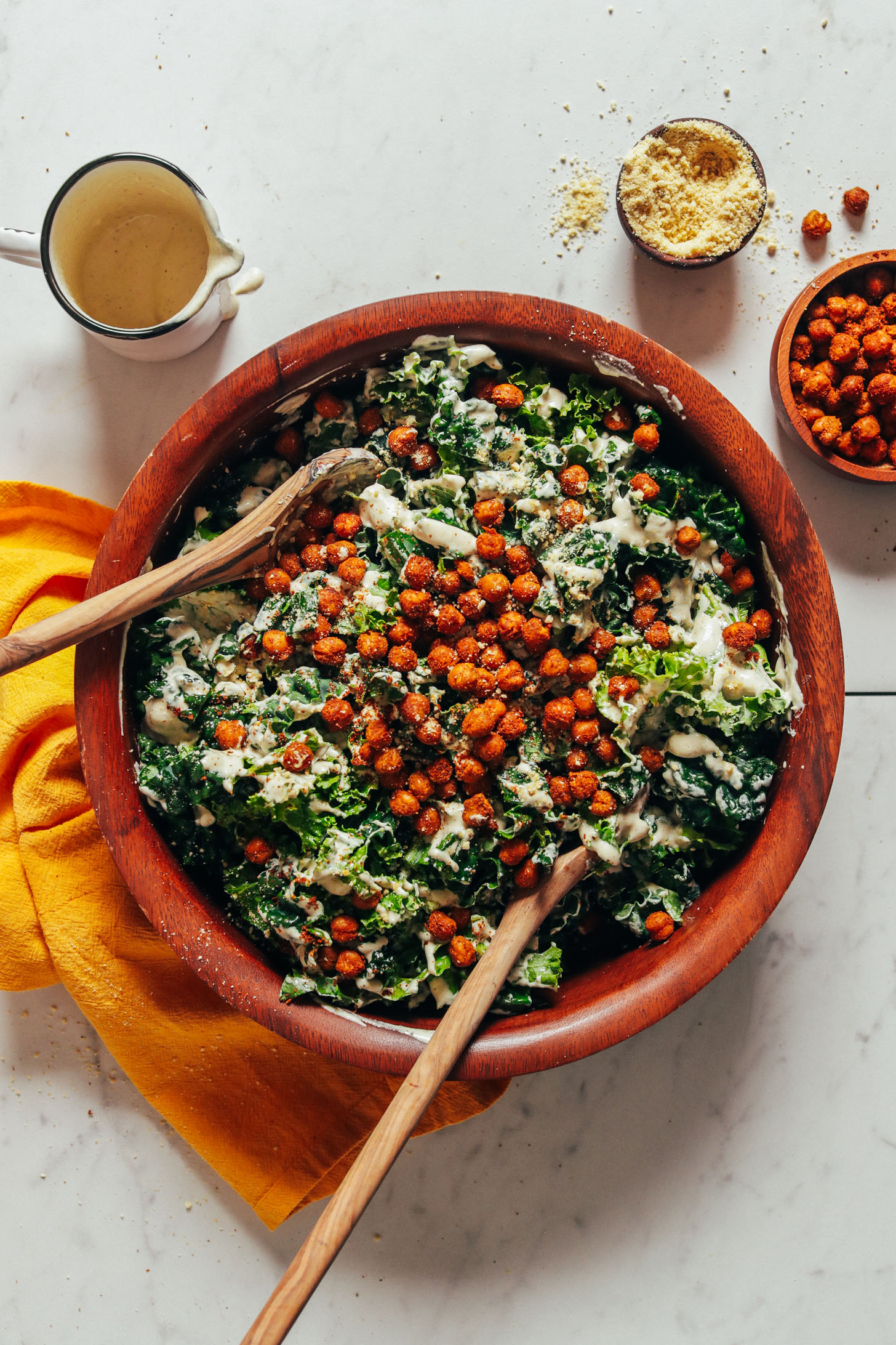 Wooden bowl of Chickpea Kale Caesar Salad topped with tandoori chickpeas