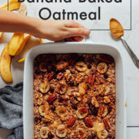 Hands holding a baking dish of vegan and gluten-free chocolate chip banana baked oatmeal
