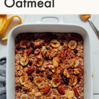 Hands holding a baking dish of vegan and gluten-free chocolate chip banana baked oatmeal