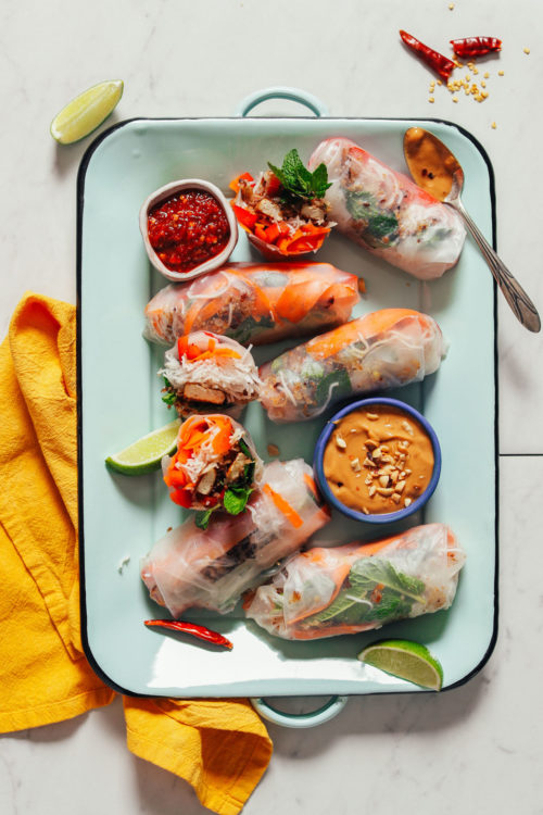 Tray of Crispy Shallot Spring Rolls with bowls of chili garlic and peanut sauces