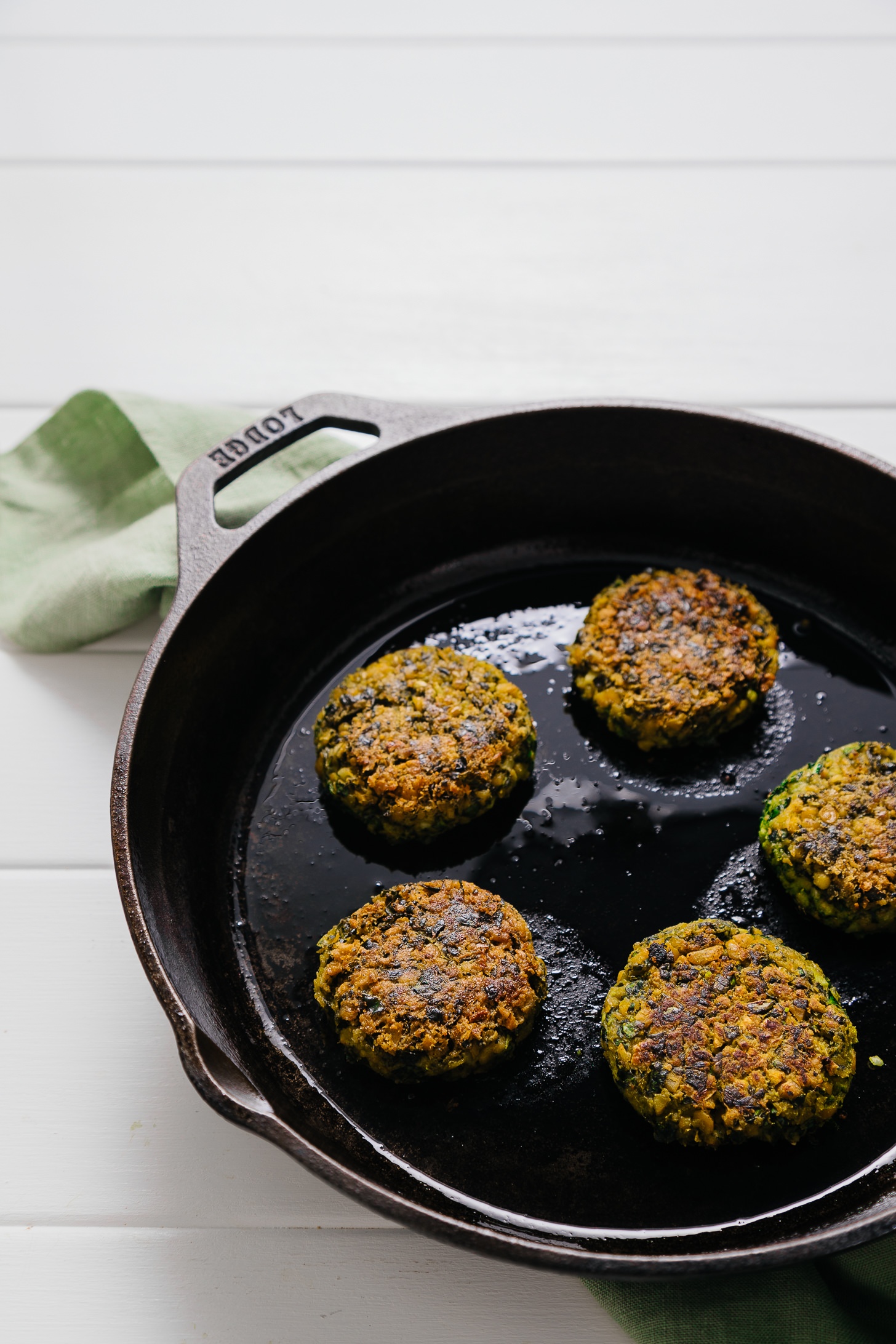Healthy Kale Falafel cooking in a cast-iron skillet