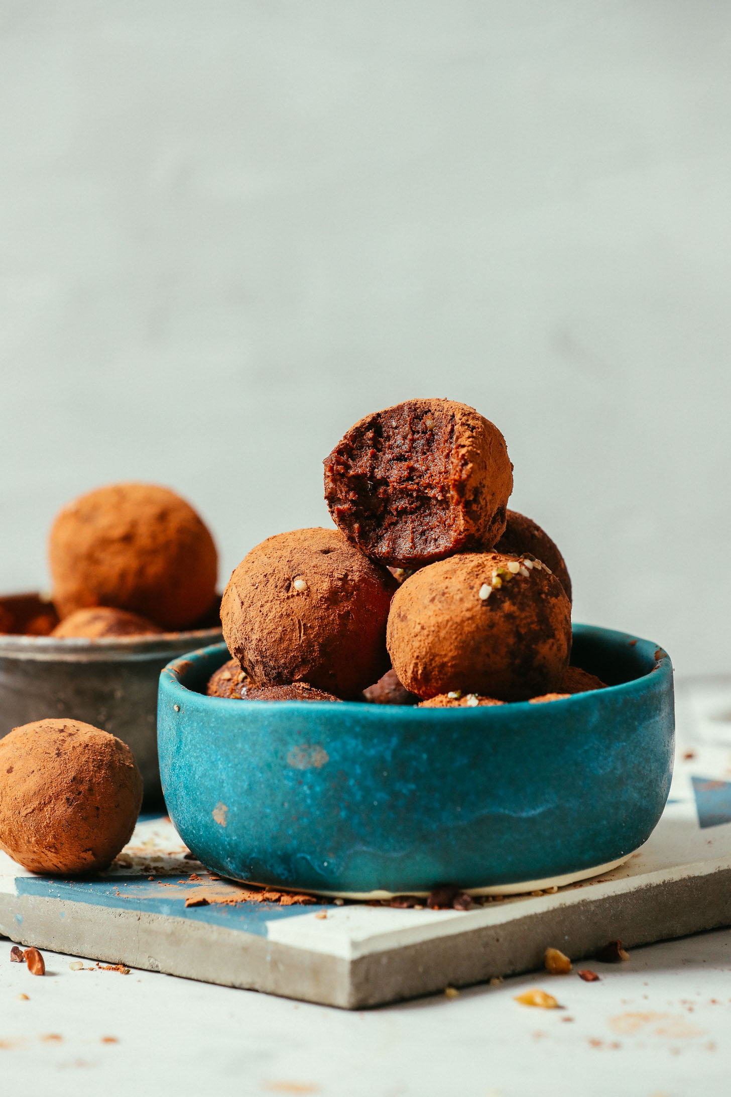 Bowl piled high with Brownie Bliss Balls with the top one partially eaten