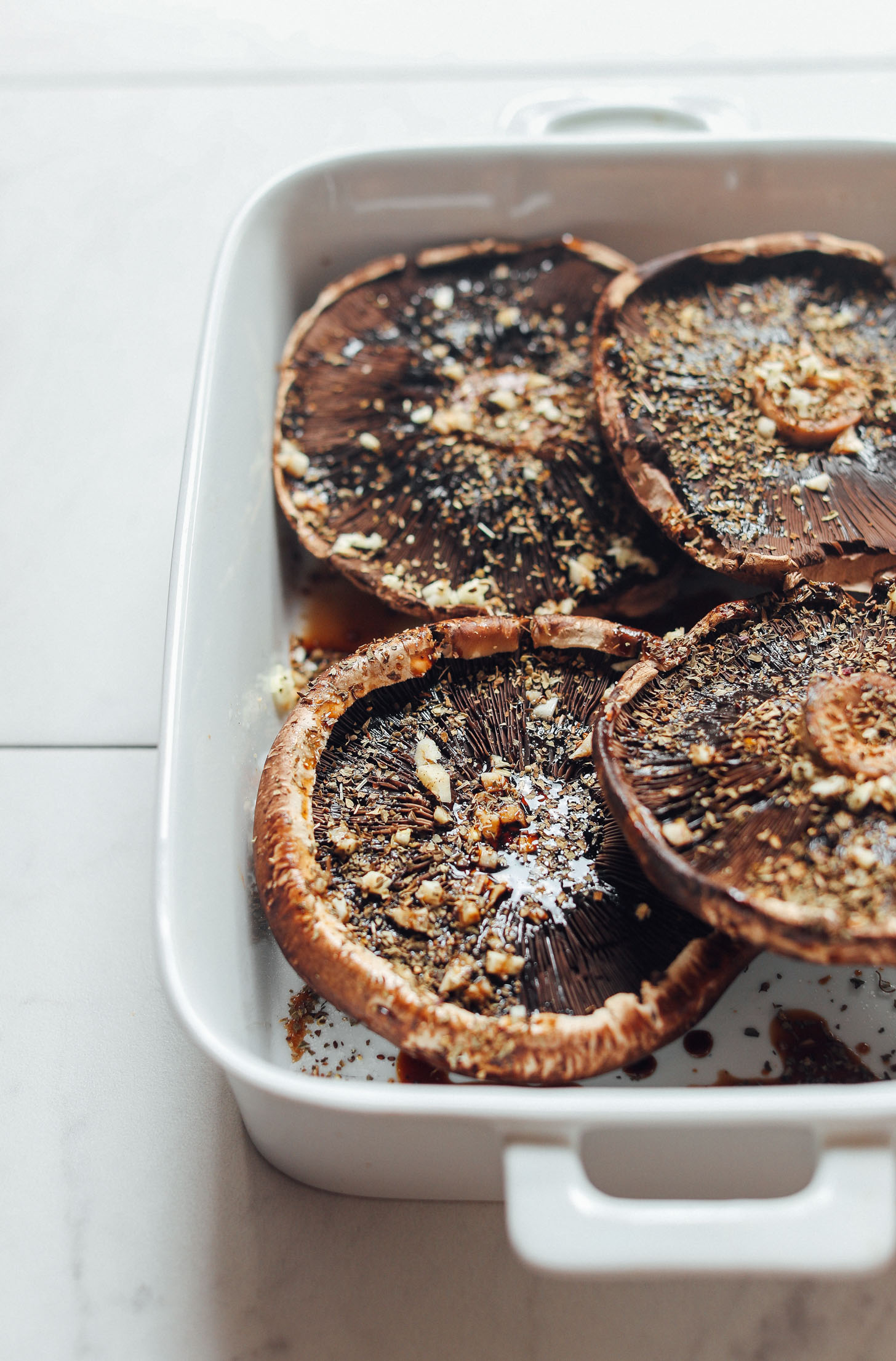 Baking pan filled with Balsamic Marinated Portobello Mushrooms topped with garlic and herbs