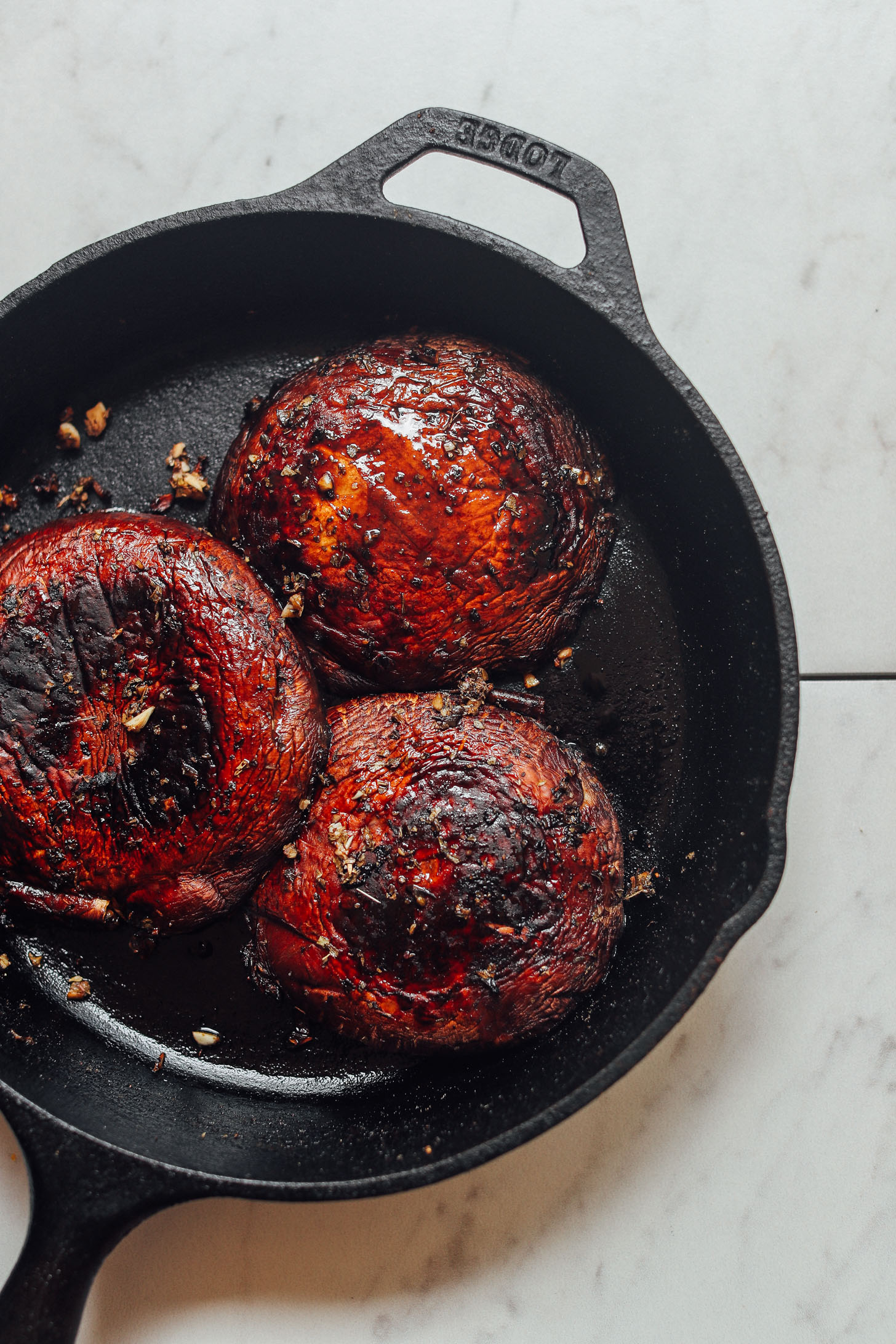 Cast-iron skillet of perfectly browned Balsamic Marinated Portobello Burgers