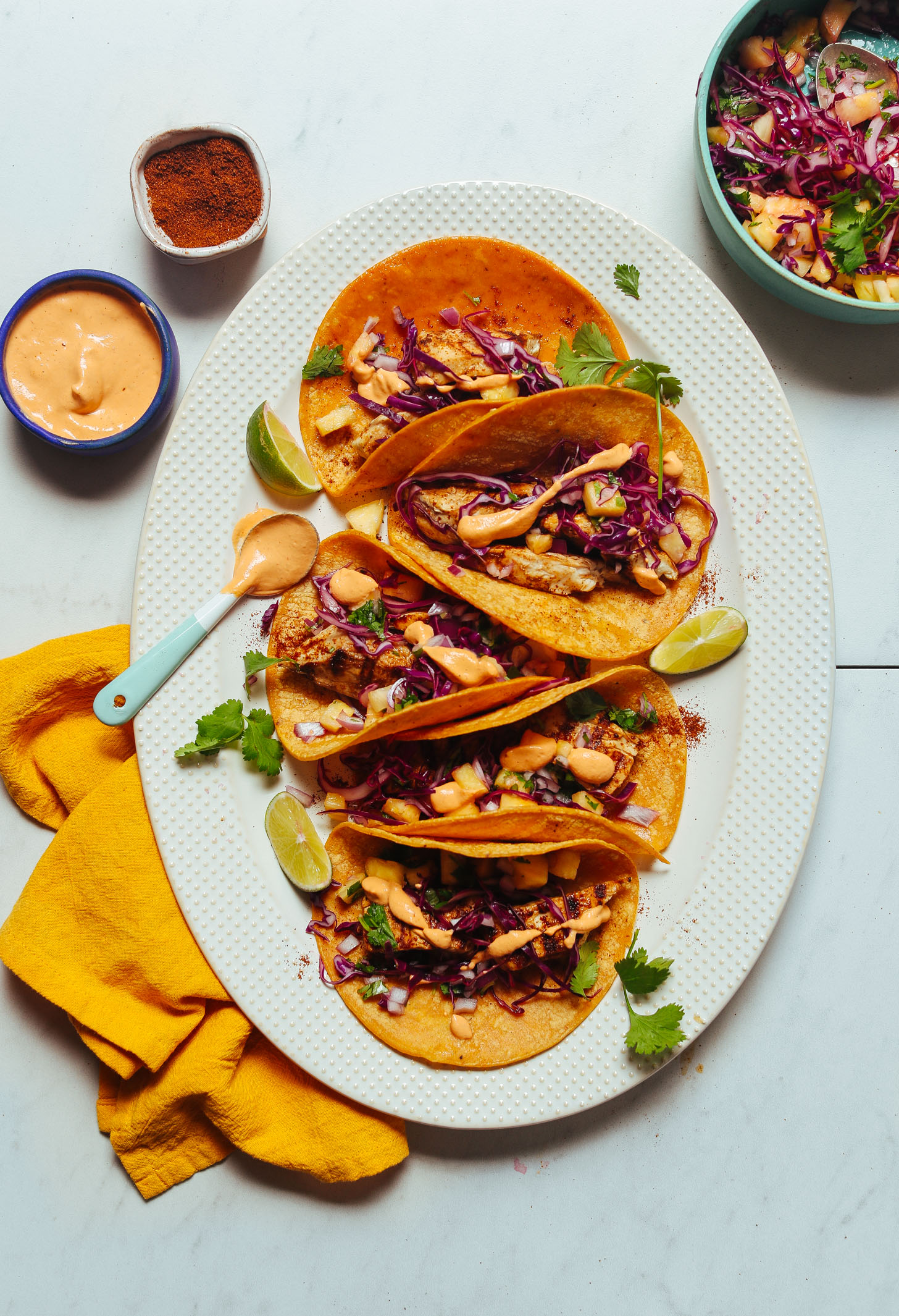 Platter of fish tacos topped with Pineapple Cabbage Slaw and Chipotle Aioli