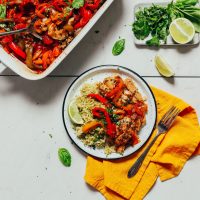 Plate and baking pan of our Baked White Fish recipe made with fresh herbs and Rainbow Bell Peppers