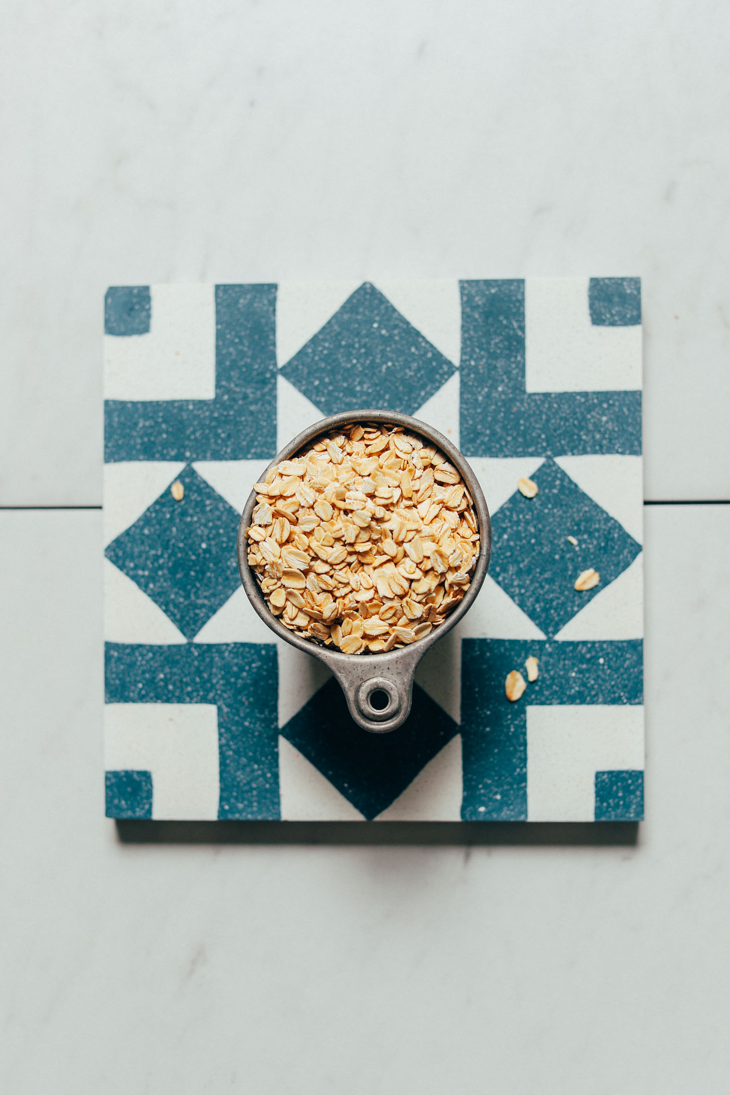 Measuring cup of rolled oats for making DIY oat flour with our tutorial