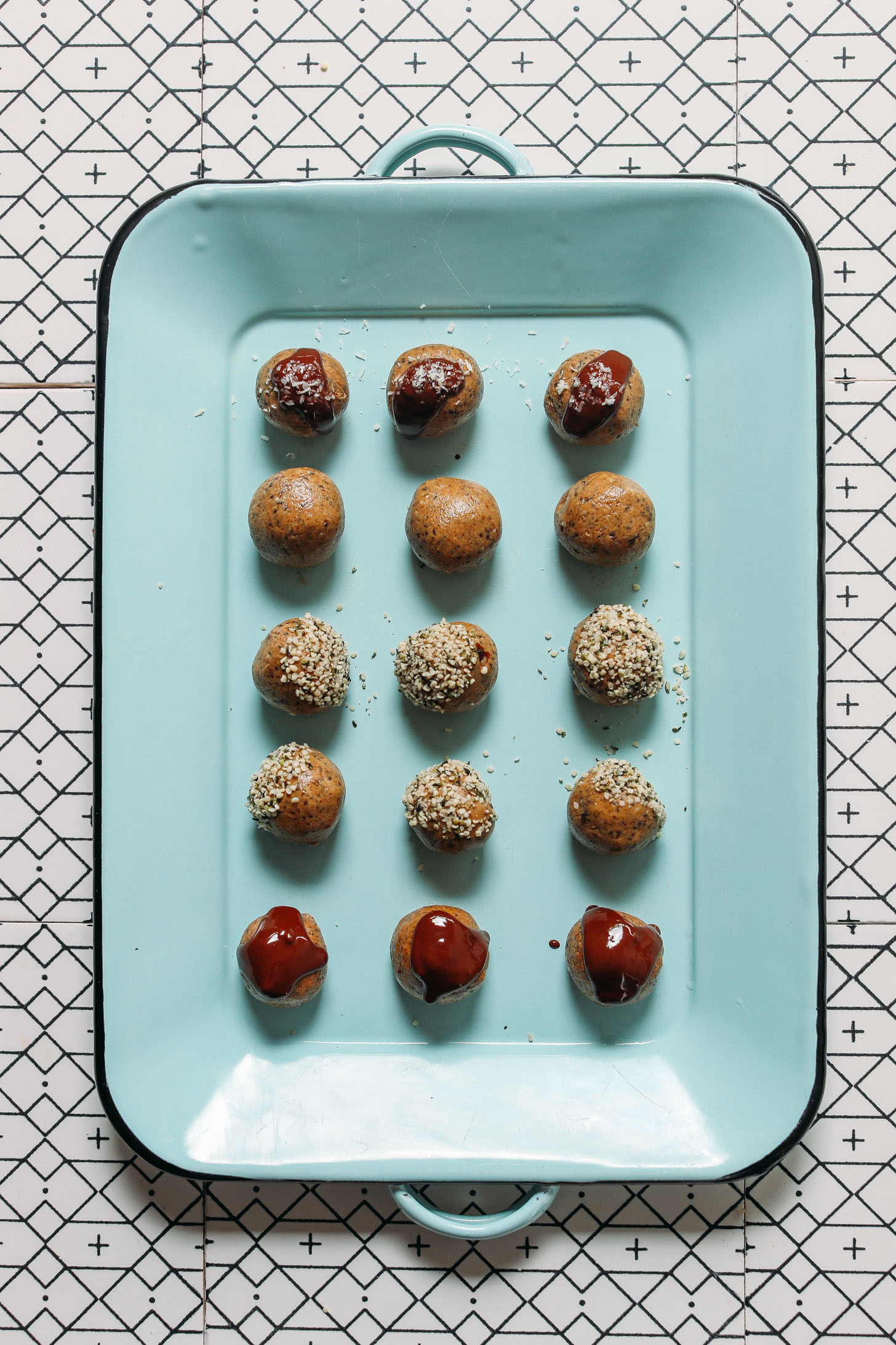 Blue tray filled with Protein Balls topped with melted chocolate and hemp seeds