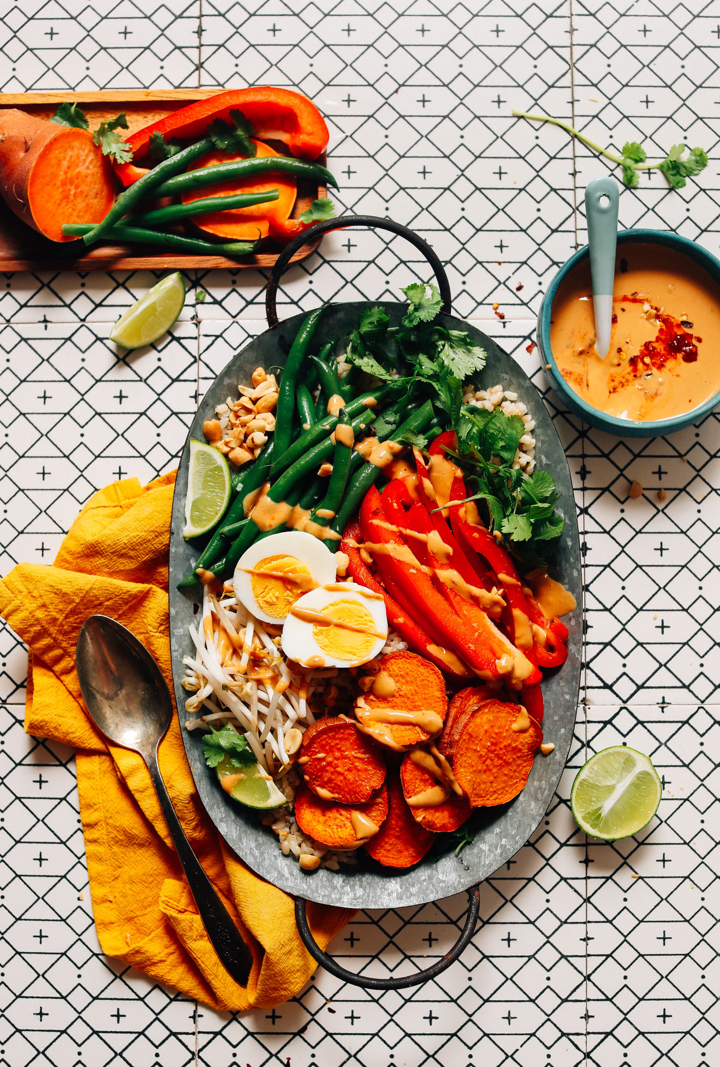 Tray of gluten-free Gado Gado made with brown rice, veggies, boiled egg, and a Spicy Peanut Sauce