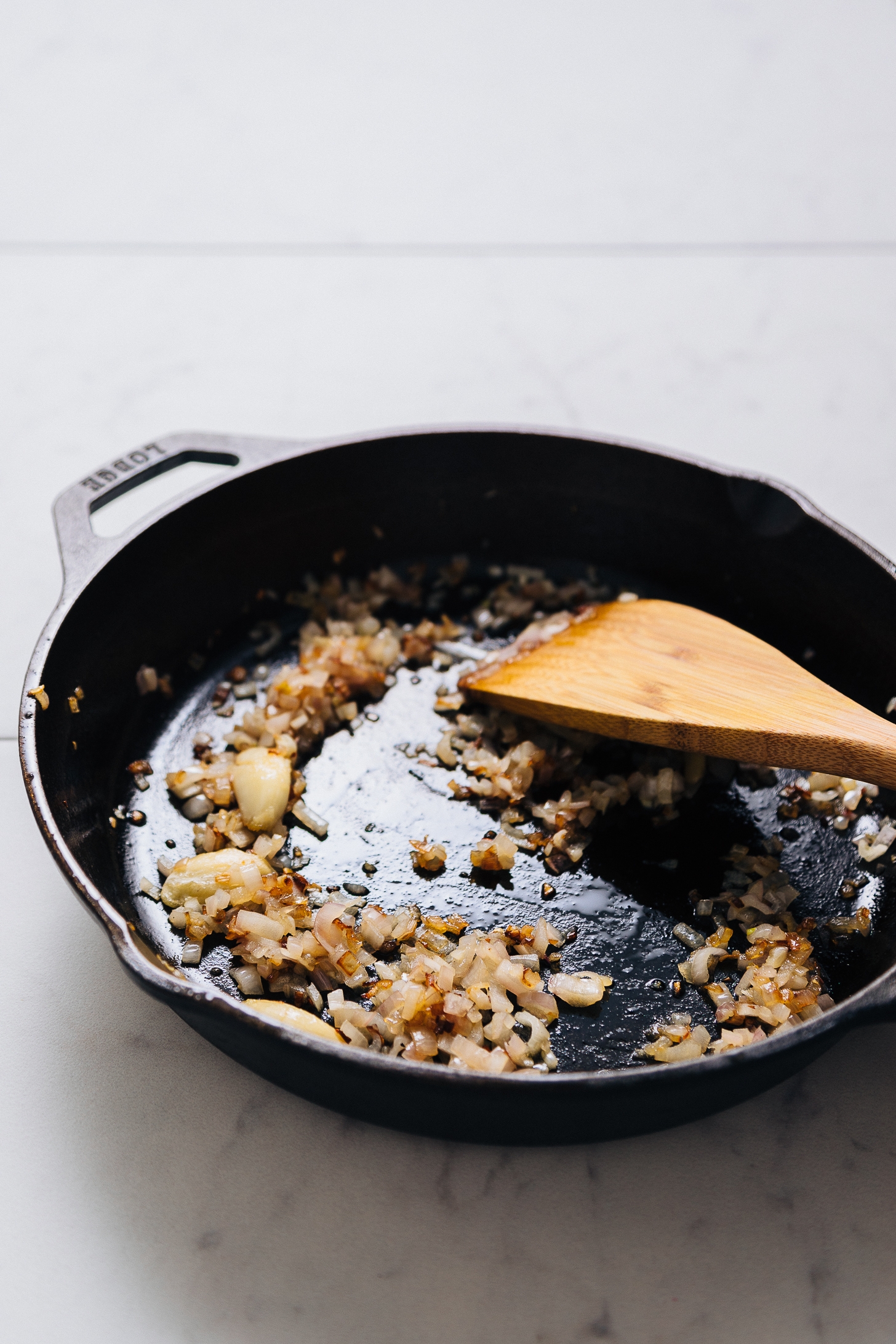 Sautéing shallot in a cast iron skillet for our Green Pea Curry Hummus recipe
