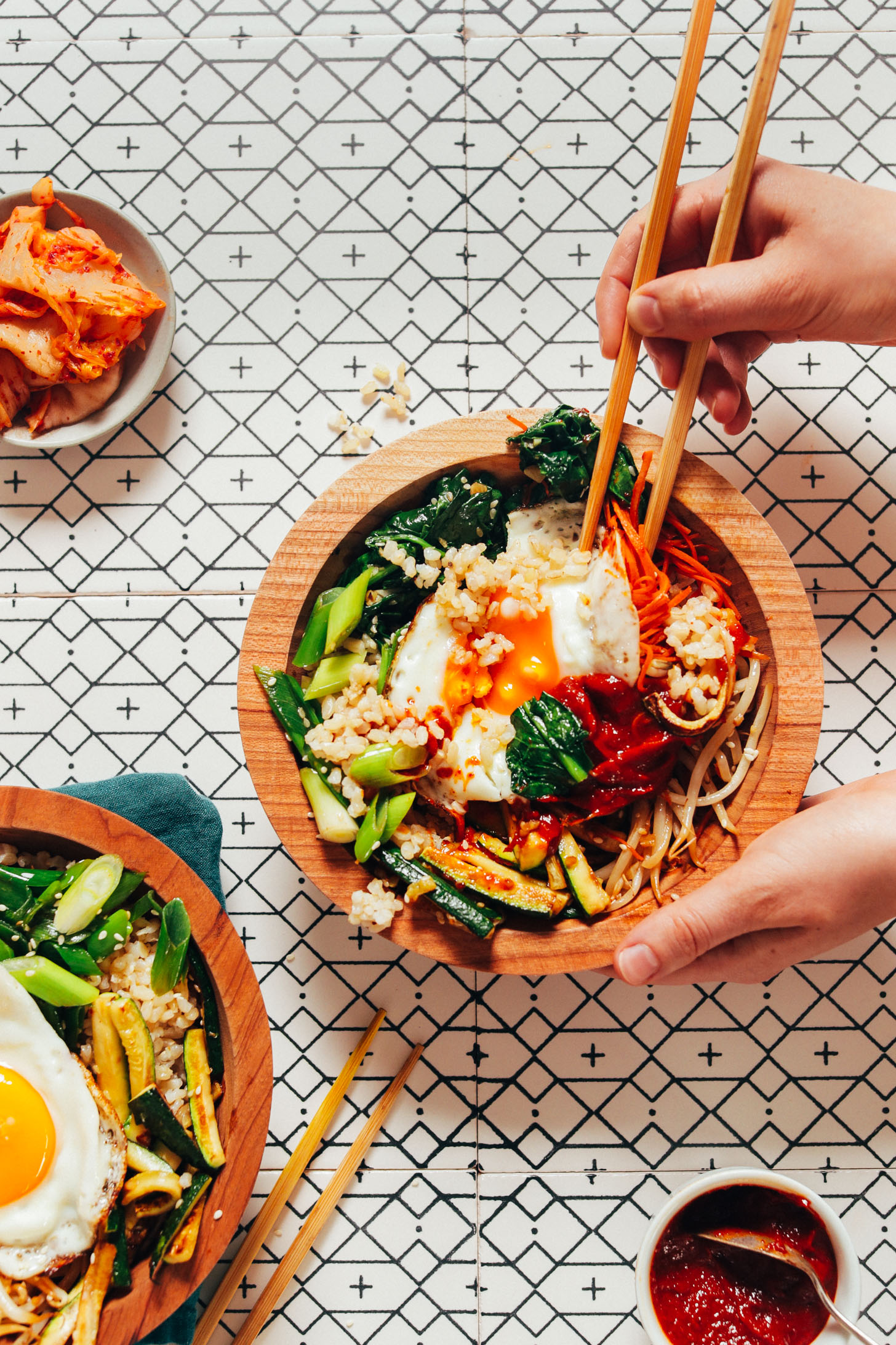 Using chopsticks to pick up a bite of a delicious homemade Korean Bibimbap bowl
