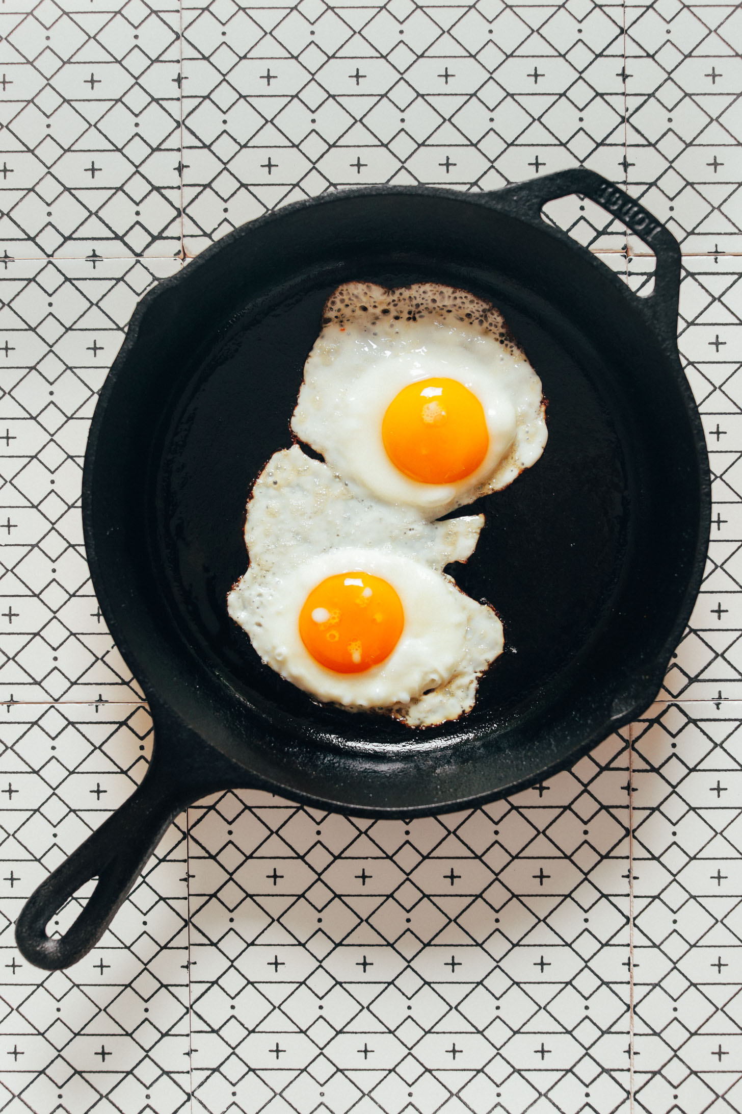 Two fried eggs in a cast-iron skillet for making Bibimbap