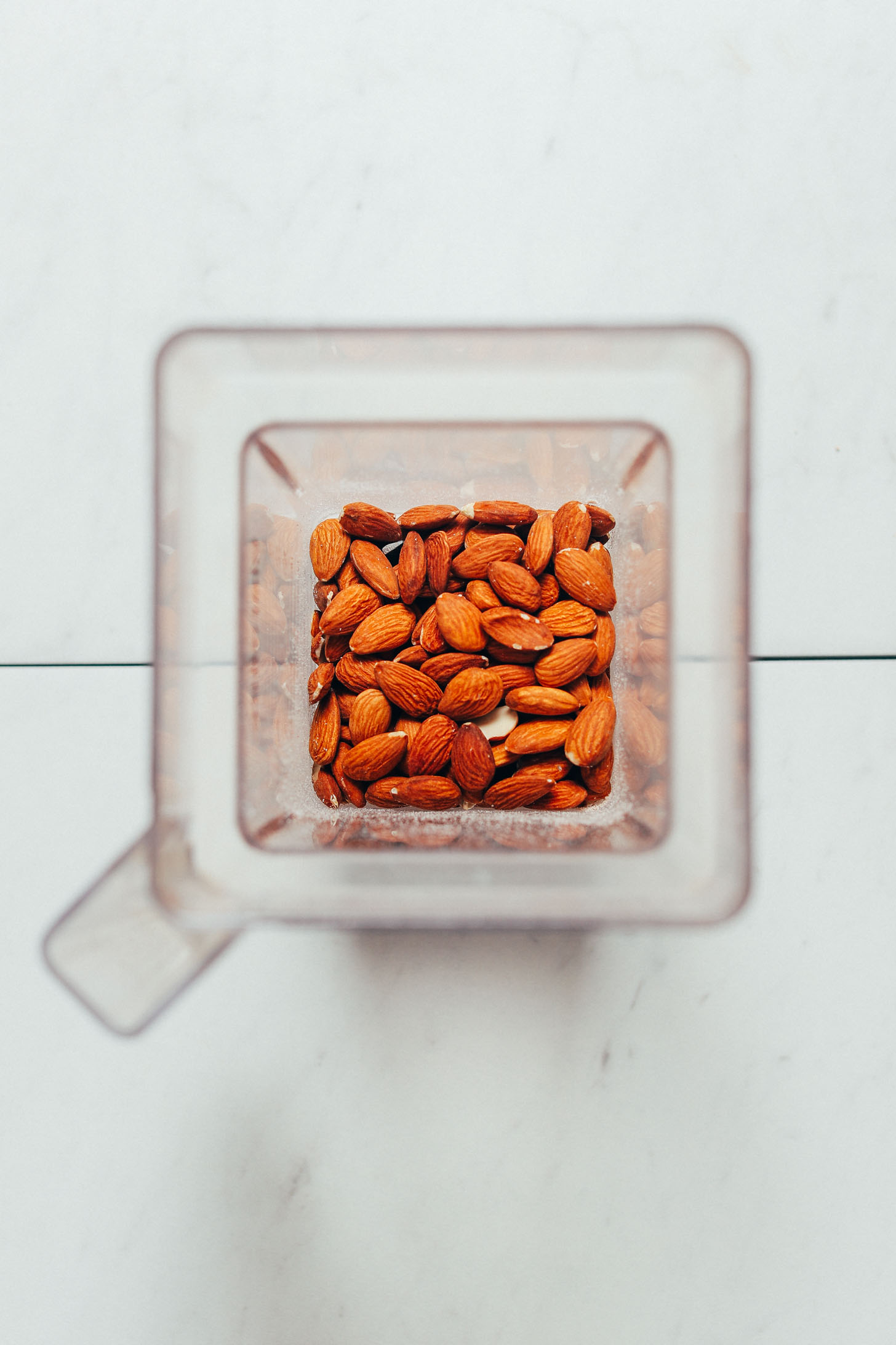 Blender filled with raw whole almonds for making almond meal