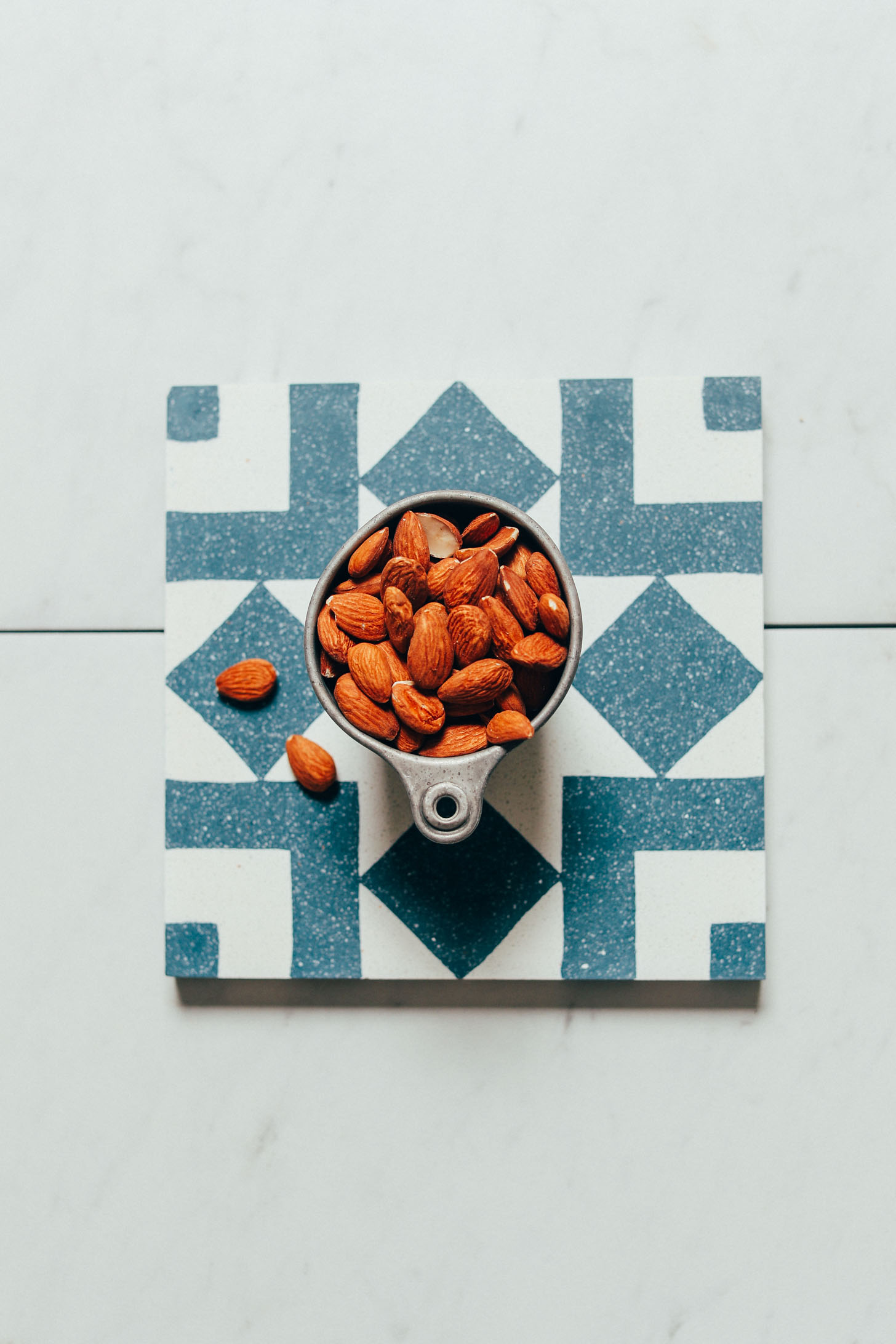 Measuring cup of raw almonds