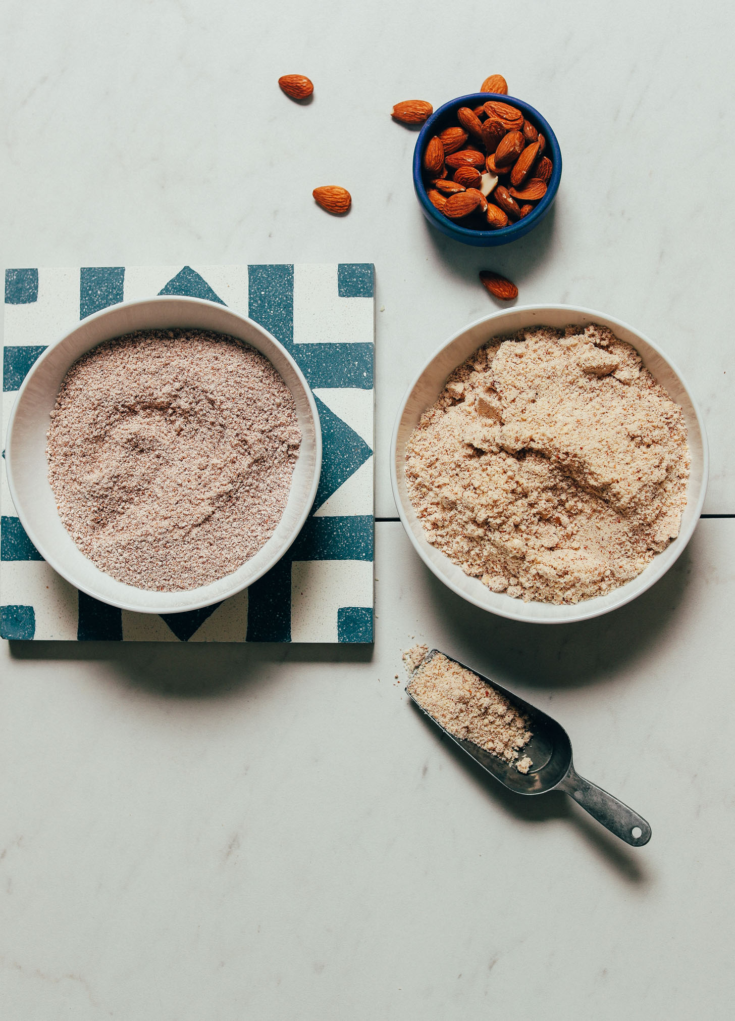 Bowls of almond meal, one made from almond pulp leftover from making nut milk