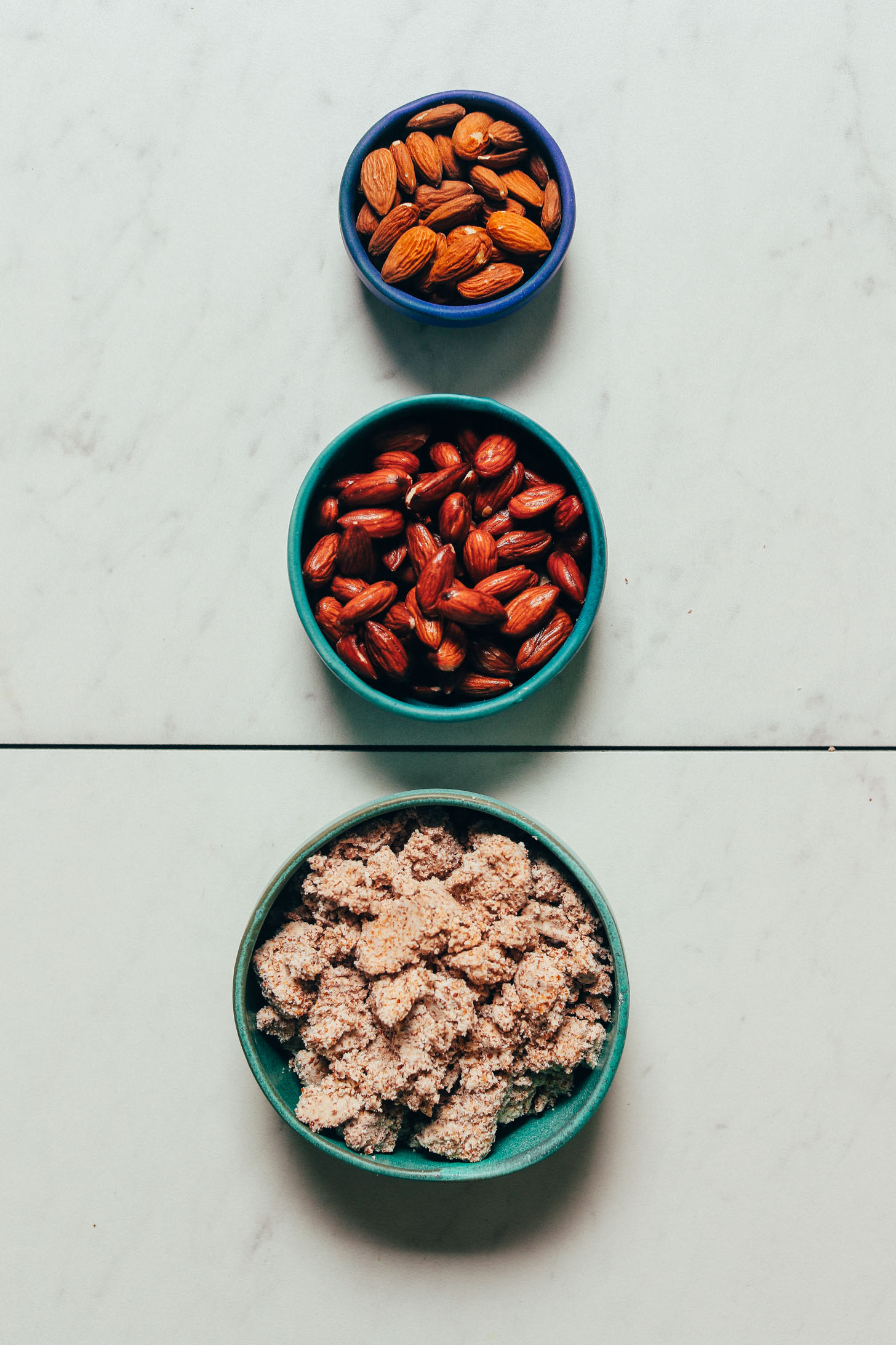 Bowls of raw almonds, soaked almonds, and almond pulp for our tutorial on How to Make Almond Meal from Almond Pulp