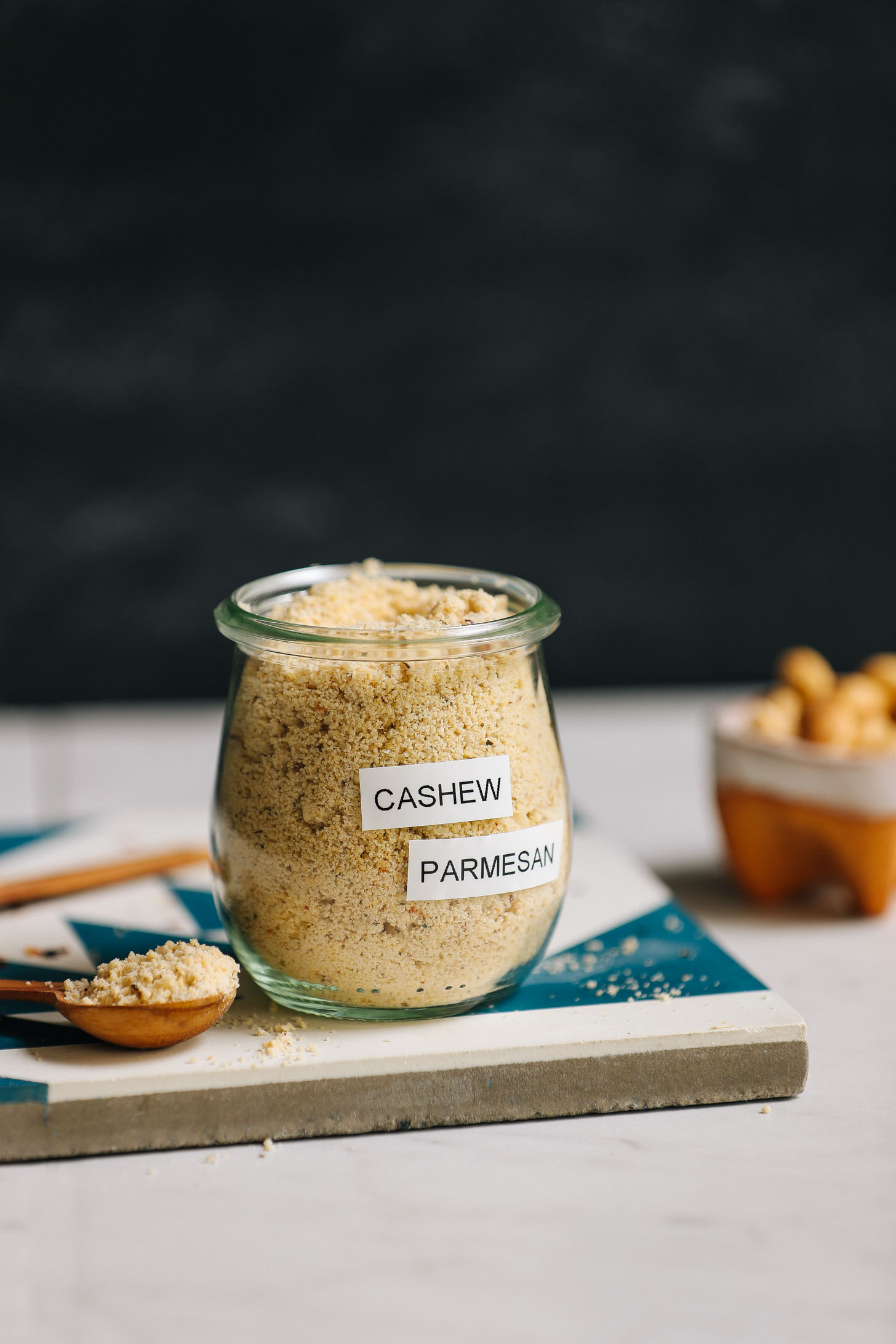 Spoonful and jar of Vegan Cashew Parmesan Cheese made without nutritional yeast